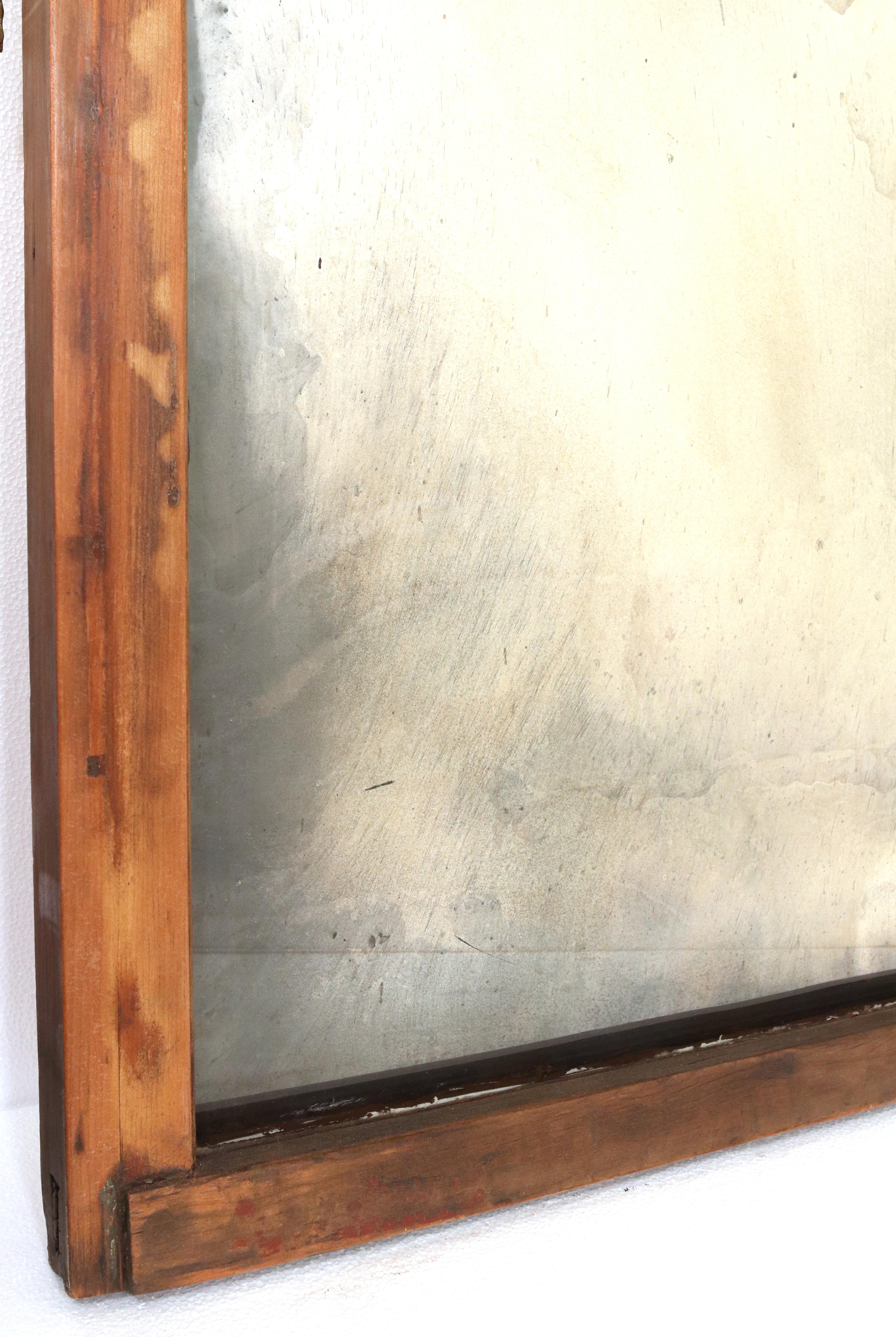 Un miroir mural recyclé fabriqué à partir d'une fenêtre récupérée du début du 20e siècle. Le verre a été argenté à la main selon le procédé original des années 1900 pour le transformer en un miroir vieilli. Le cadre de la fenêtre comporte encore la