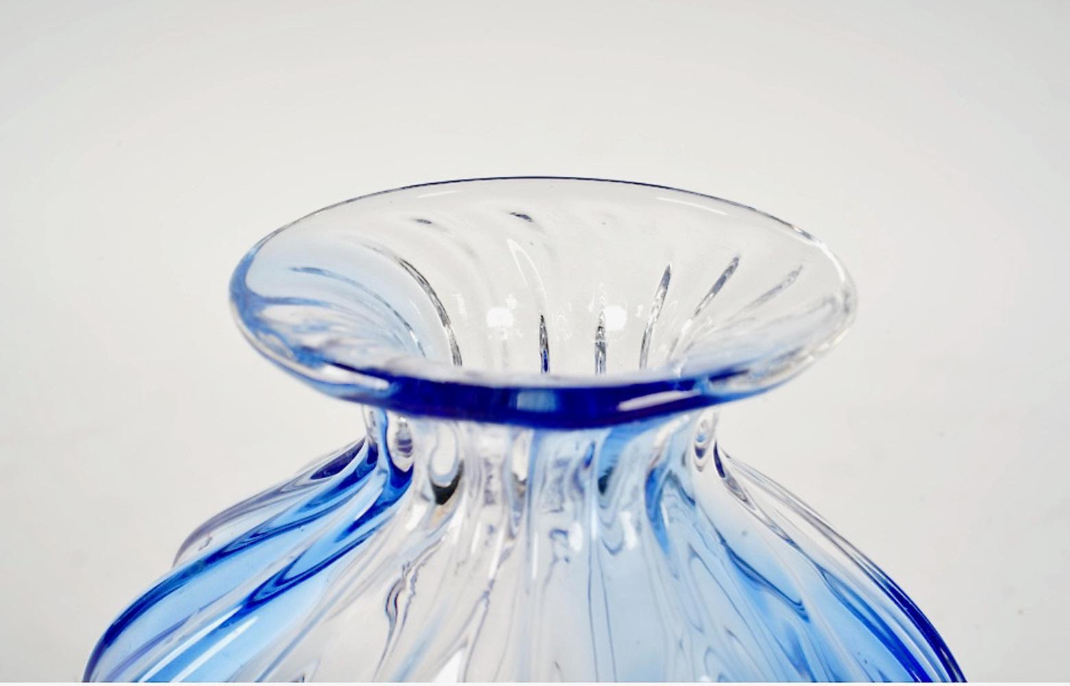 This is a very good example of the work of Archimide Seguso. The small vase of swirled blue and clear glass is signed with an etched signature. The last photo shows the vase under black light; the glass flouresces under uv lighting indicating that
