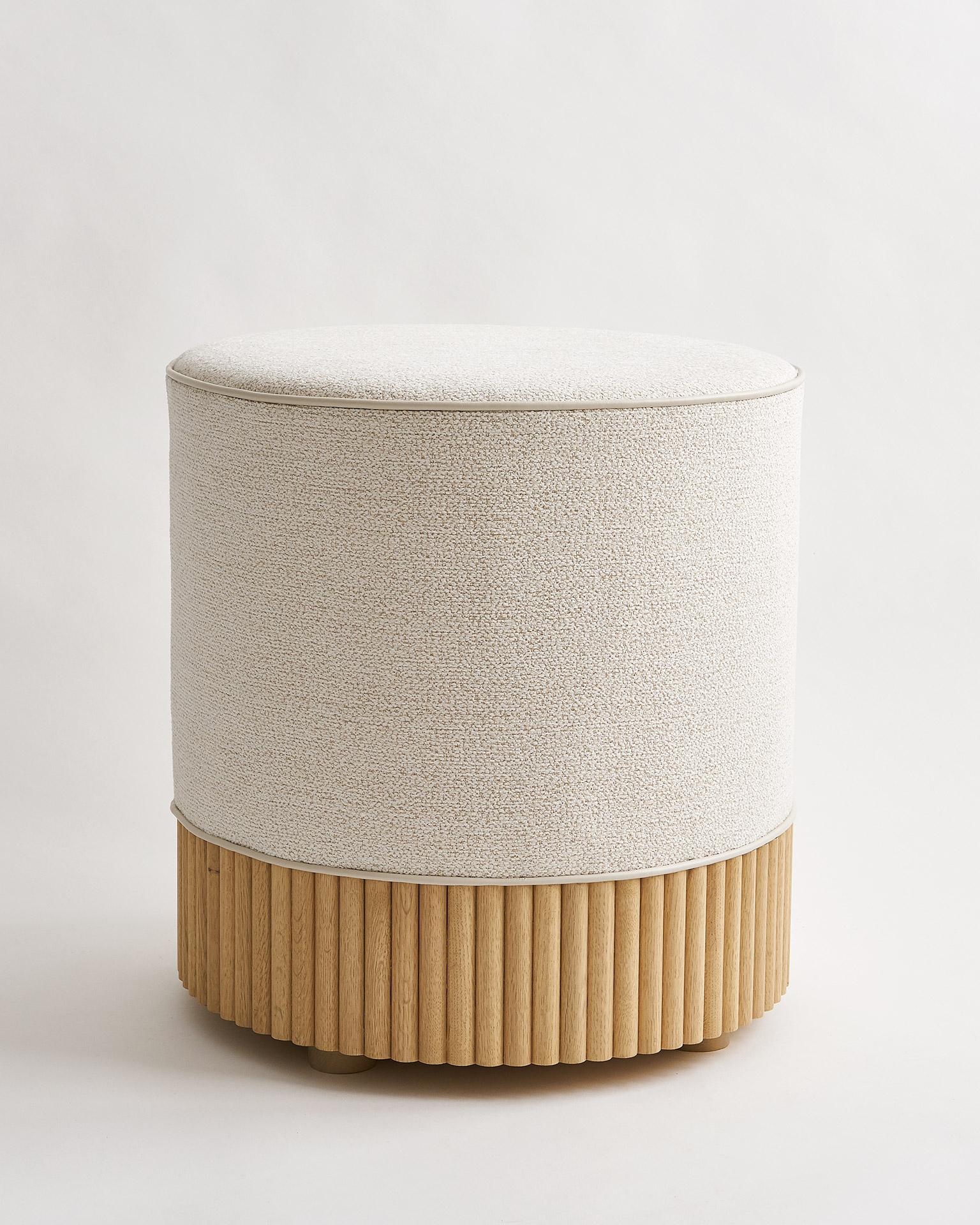 This customizable, made-to-order, modern round ottoman is part of the Studio Line collection, known as our Archer Ottoman. Upholstered in Kravet performance fabric. Includes vinyl piping detail along top with vertical white oak slat detailing at the