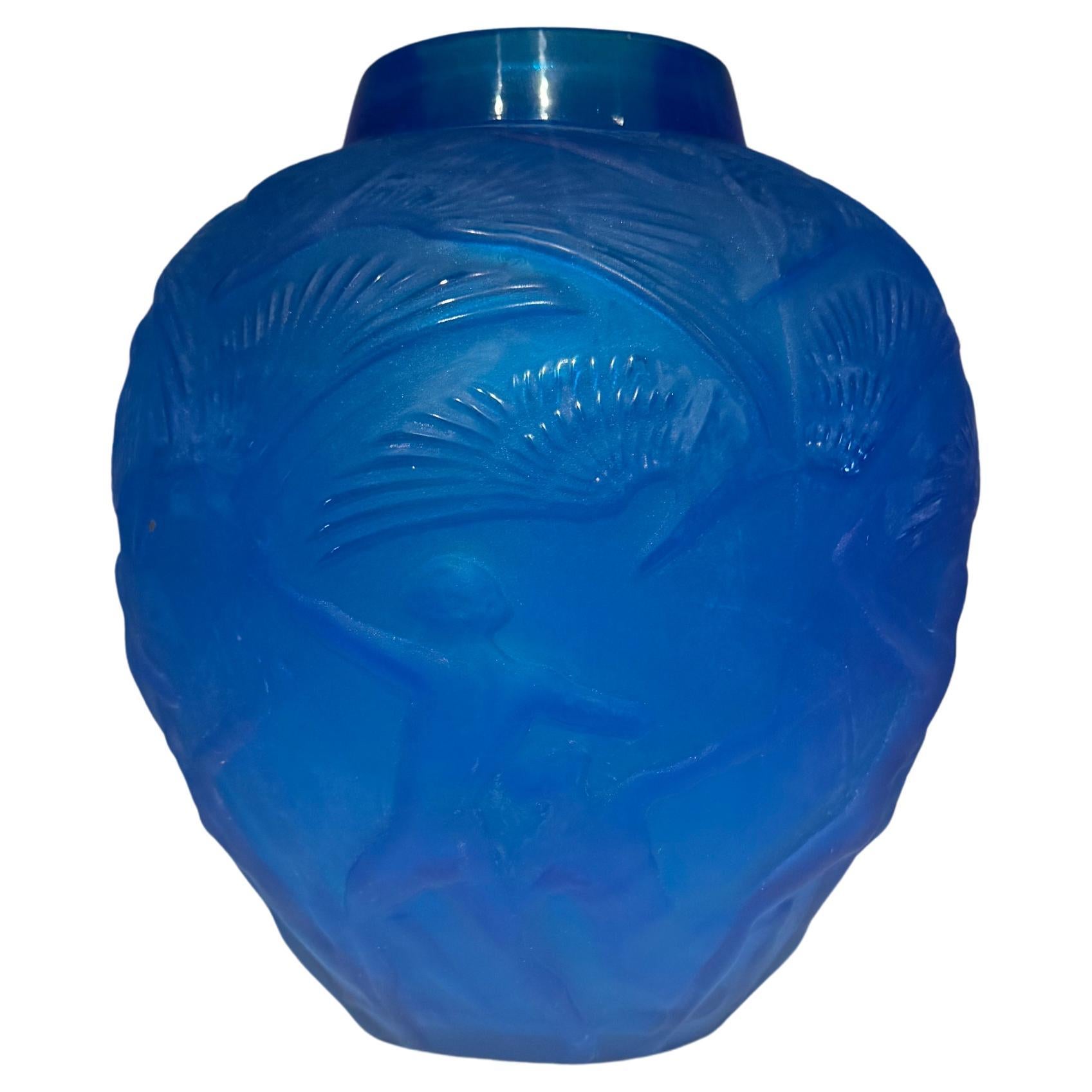 A striking 'Archers' vase in electric blue molded glass, inspired by the iconic design of René Lalique. This oviform vase showcases a captivating depiction of archers with birds hovering above, echoing the elegance and innovation that made Lalique's