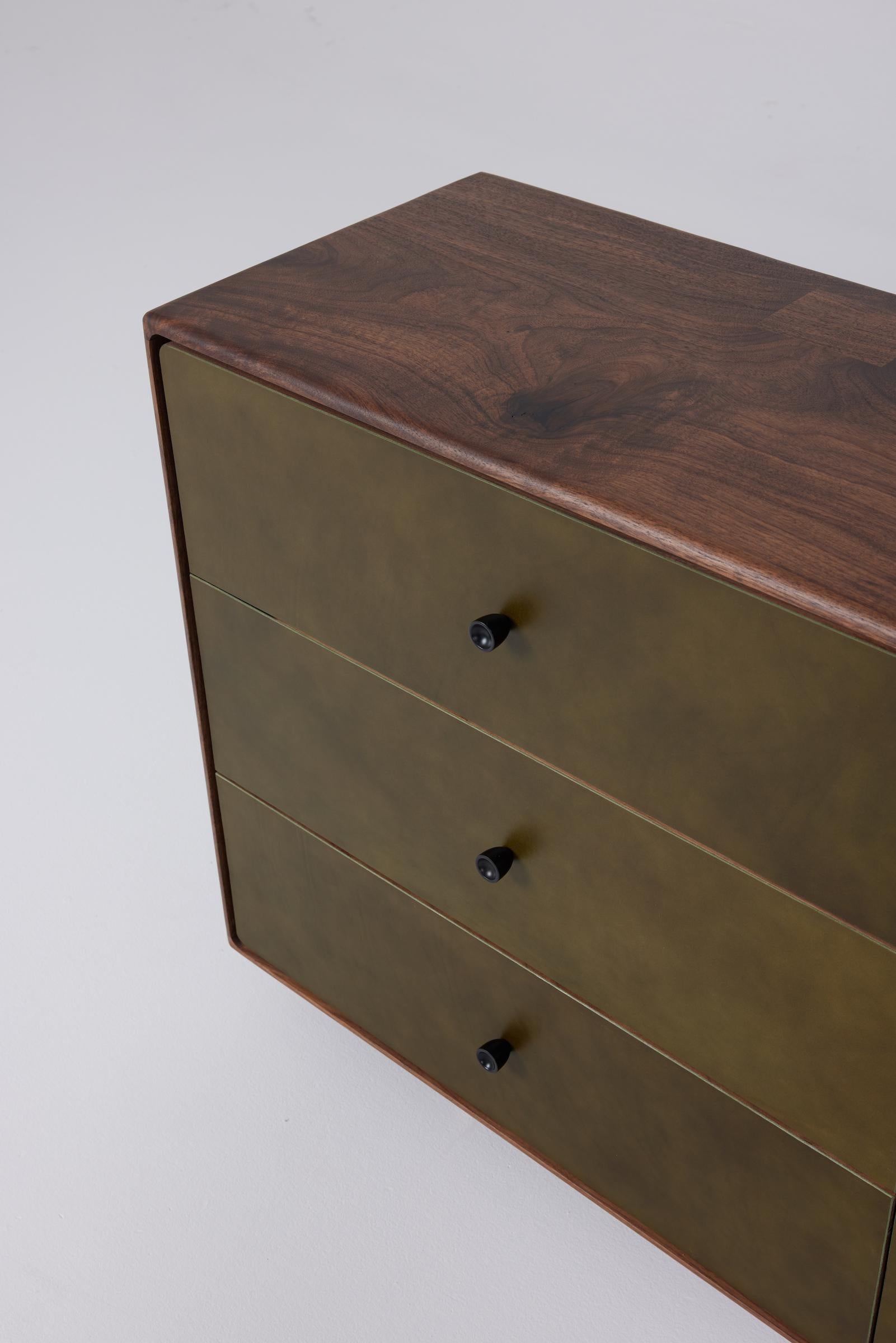 La serie Archibald continua con il nostro comò di punta. Un linguaggio di design morbido e sottile, che pone l'accento sul tatto e sulla sensazione, dai bordi arrotondati a mano ai frontali dei cassetti in pelle laminata.

La base annerita è fornita
