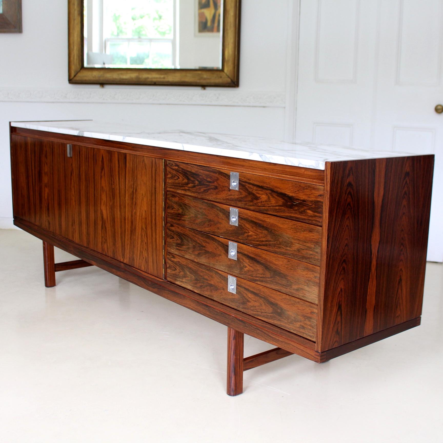 An outstanding Brazilian rosewood sideboard designed by Robert Heritage for Archie Shine.

Fitted with the original ultra rare white marble top.

A double door cabinet enclosed shelving flanked by a column of fitted drawers - the top drawer with
