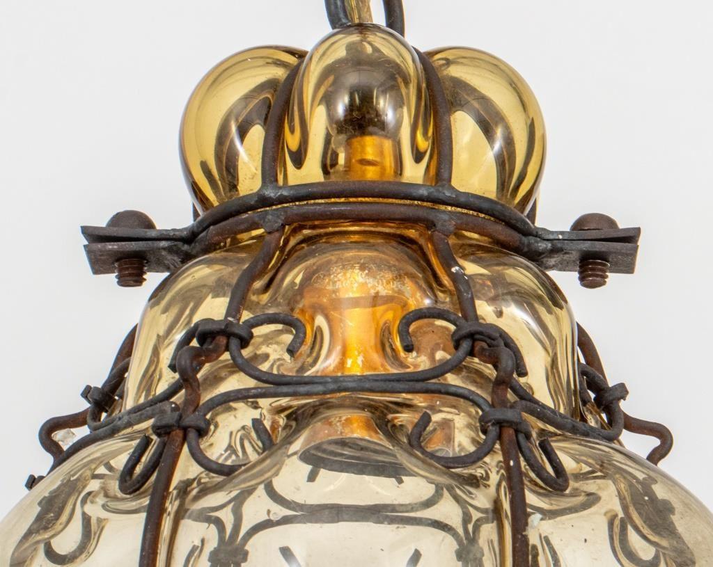Archimede Seguso Attributed Amber Glass Pendant Lamp, circa 1960s, within a wrought iron cage with scrolling design. Provenance: From a New York City collection. 