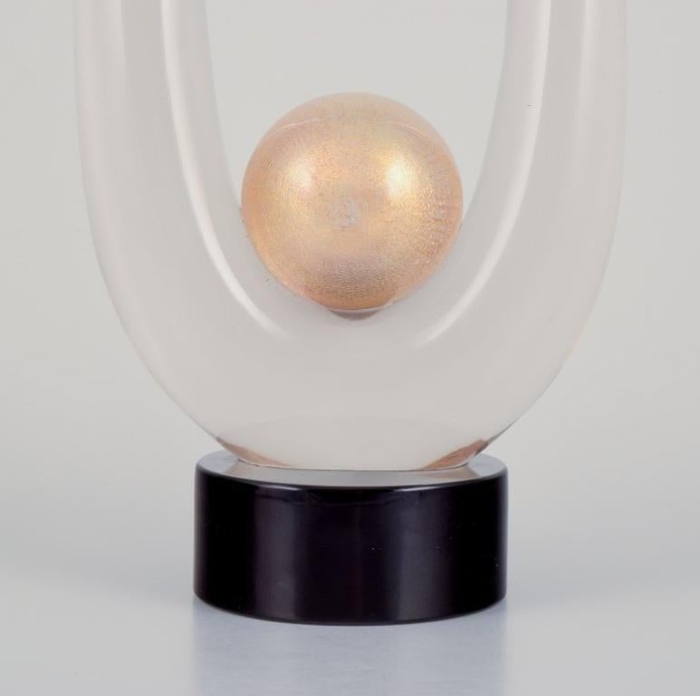 Archimede Seguso for Murano, Italy. 
Large art glass sculpture.
Clear glass on a black base with a gold-colored sphere. Mouth-blown.
1970s.
Signed and labeled.
In perfect condition.
Dimensions: Height 38.0 cm x Width 15.0 cm x Depth 9.0 cm.