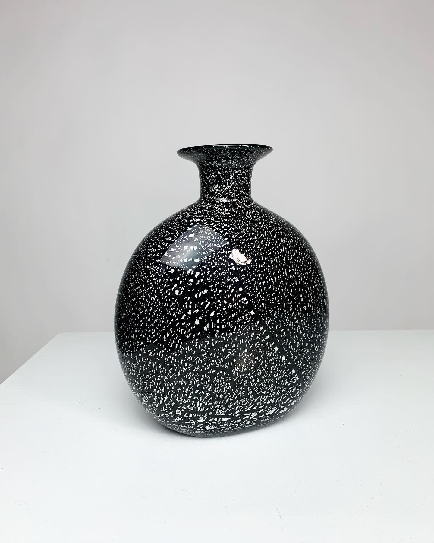Vase en verre chatoyant d'Archimede Seguso, soufflé à la bouche à Murano dans les années 1970. Verre noir avec des mouchetures d'argent, belle pièce façonnée à la main.
 
Reste l'autocollant original du fabricant.
 
Hauteur : 20 cm
Largeur : 16
