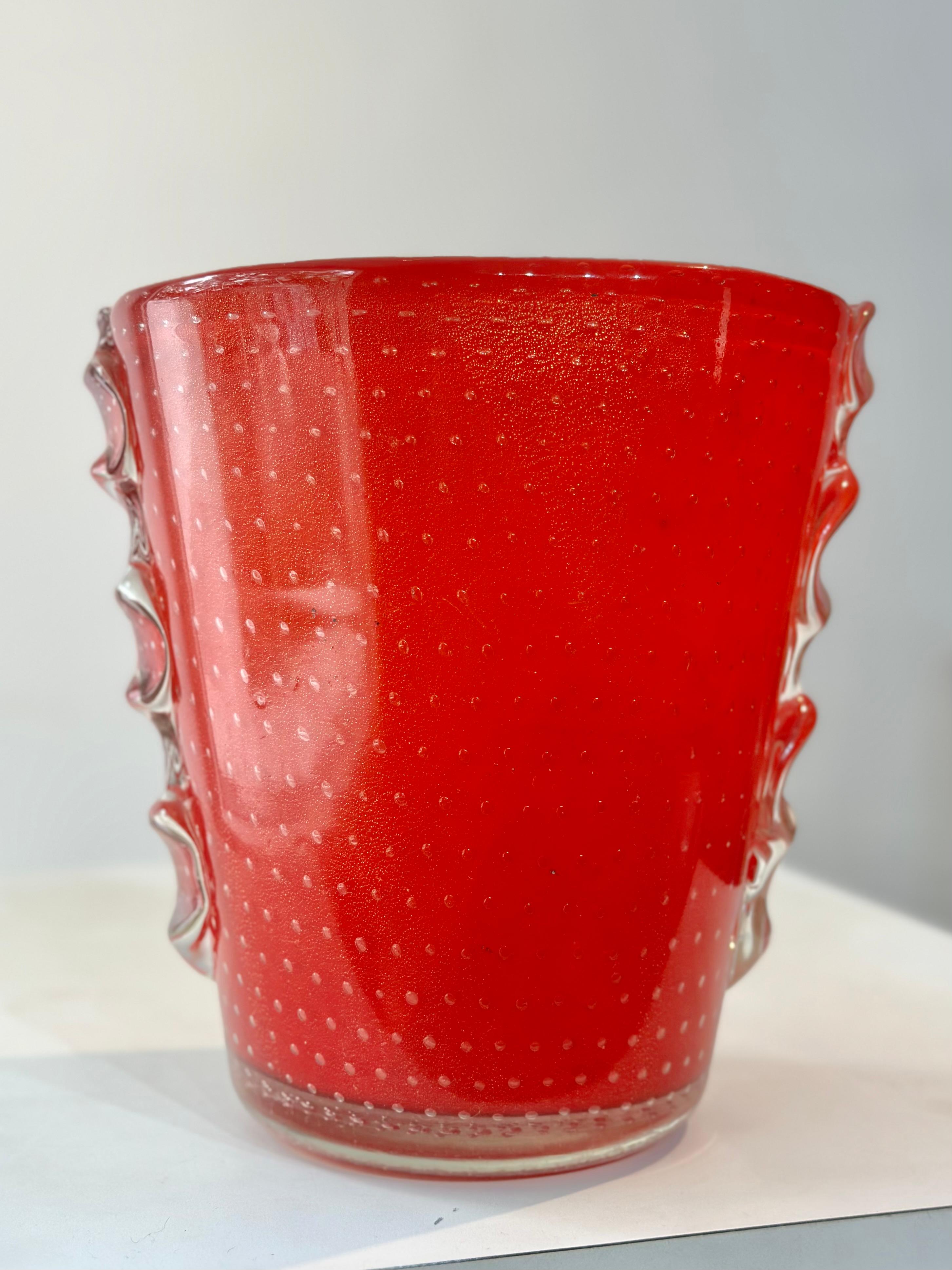 Vaso di Murano dal magnifico colore rosso caratterizzato da bolle simmetriche, in ottimo stato di conservazione. Si tratta di un oggetto molto desiderato sia per la collezione che per la decorazione grazie al suo colore radioso e alla sua bellissima
