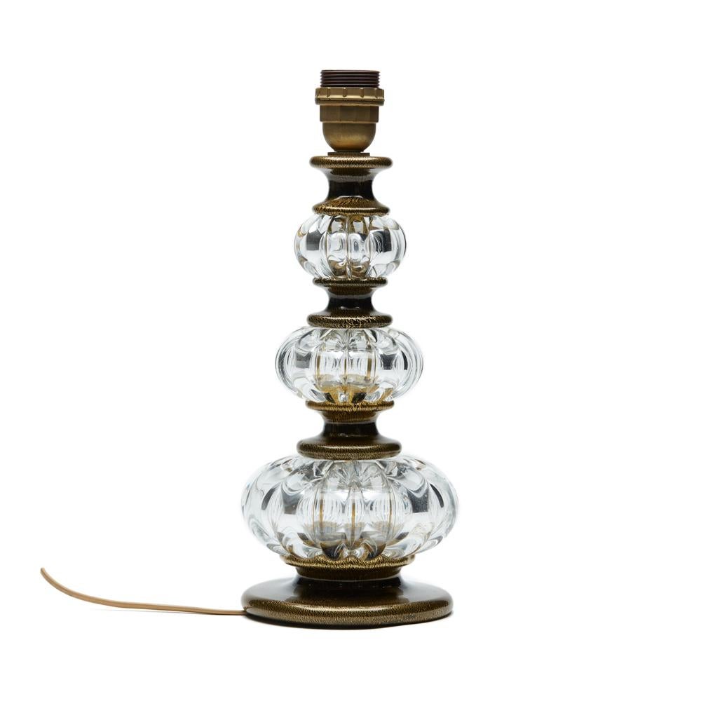 A stunning vintage Murano Archimede Seguso art glass lamp base of column-form with clear glass ribbed graduated gourd sections set between black glass spacers with gold aventurine inclusions. The lamp has a fitted screw bulb holder with a wire