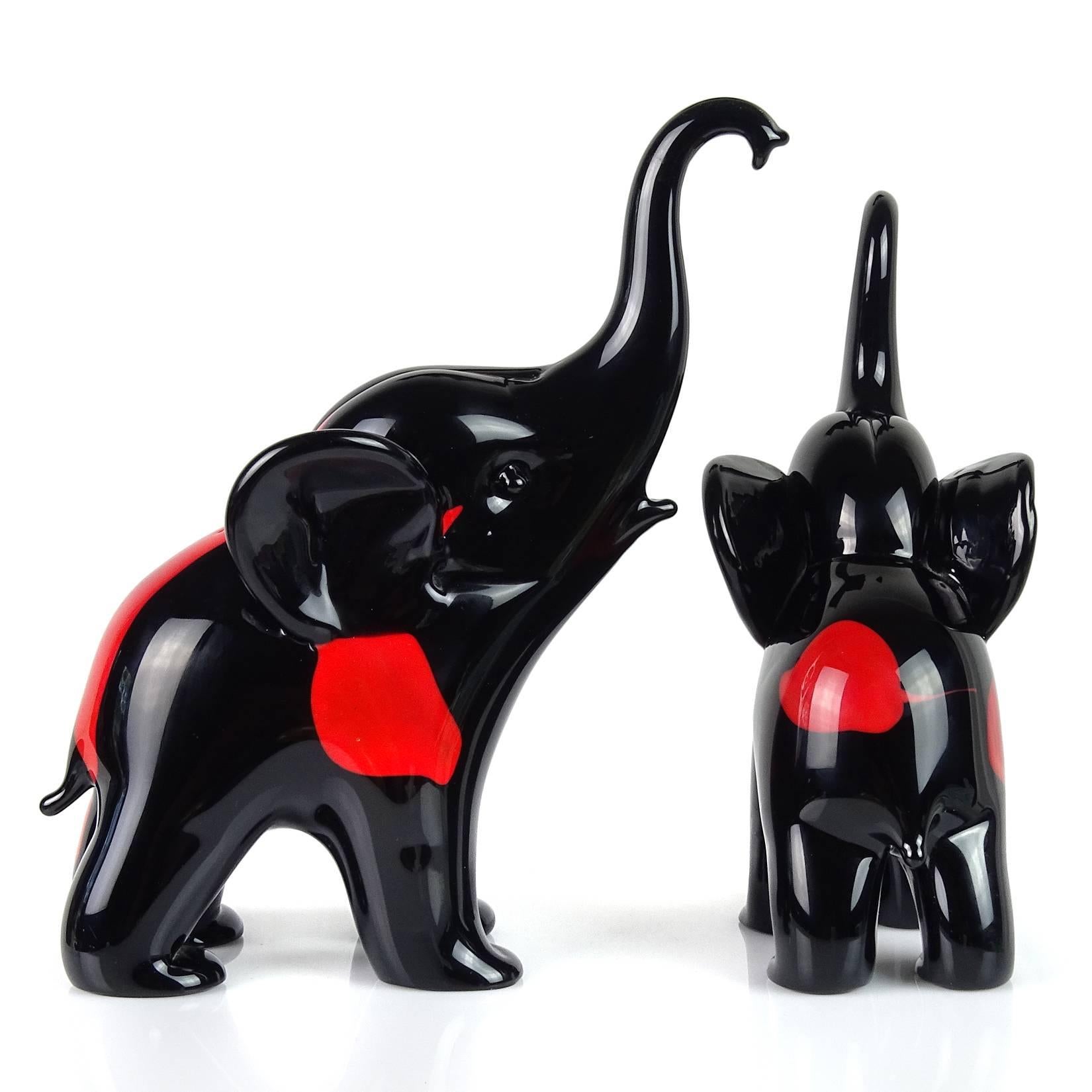 Gorgeous and rare Murano hand blown jet black and bright red spots Italian art glass elephant mom / dad and baby sculptures. Documented to designer Archimede Seguso, signed (both) underneath, from his artistic series. They measure 7 3/4