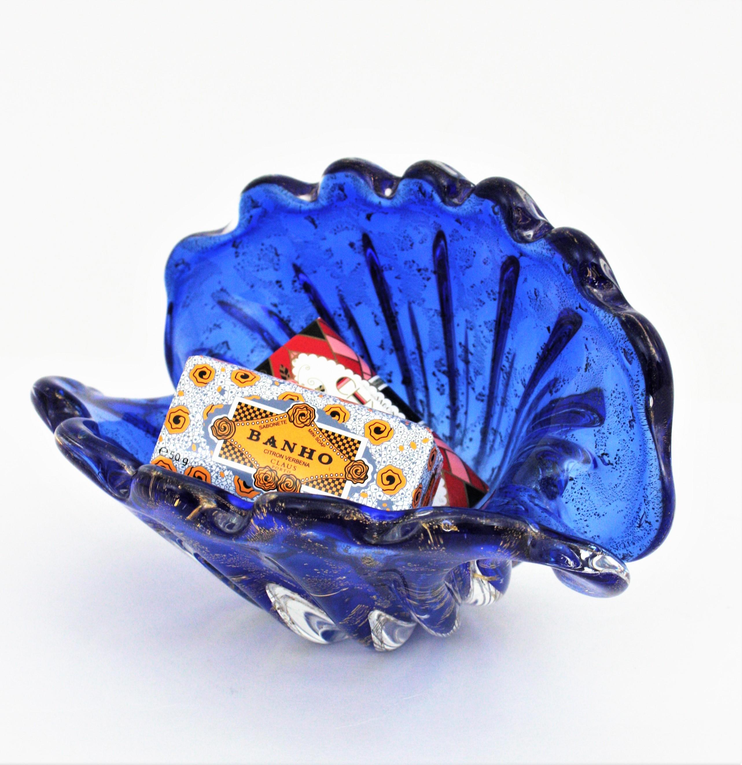 Amazing hand blown clam shell bowl in cobalt blue glass with gold flecks. Attributed to Archimede Seguso, Italy, 1950-1960.
This large clam shell bowl has an eye-catching color with blue glass submerged into clear glass with inclusions of