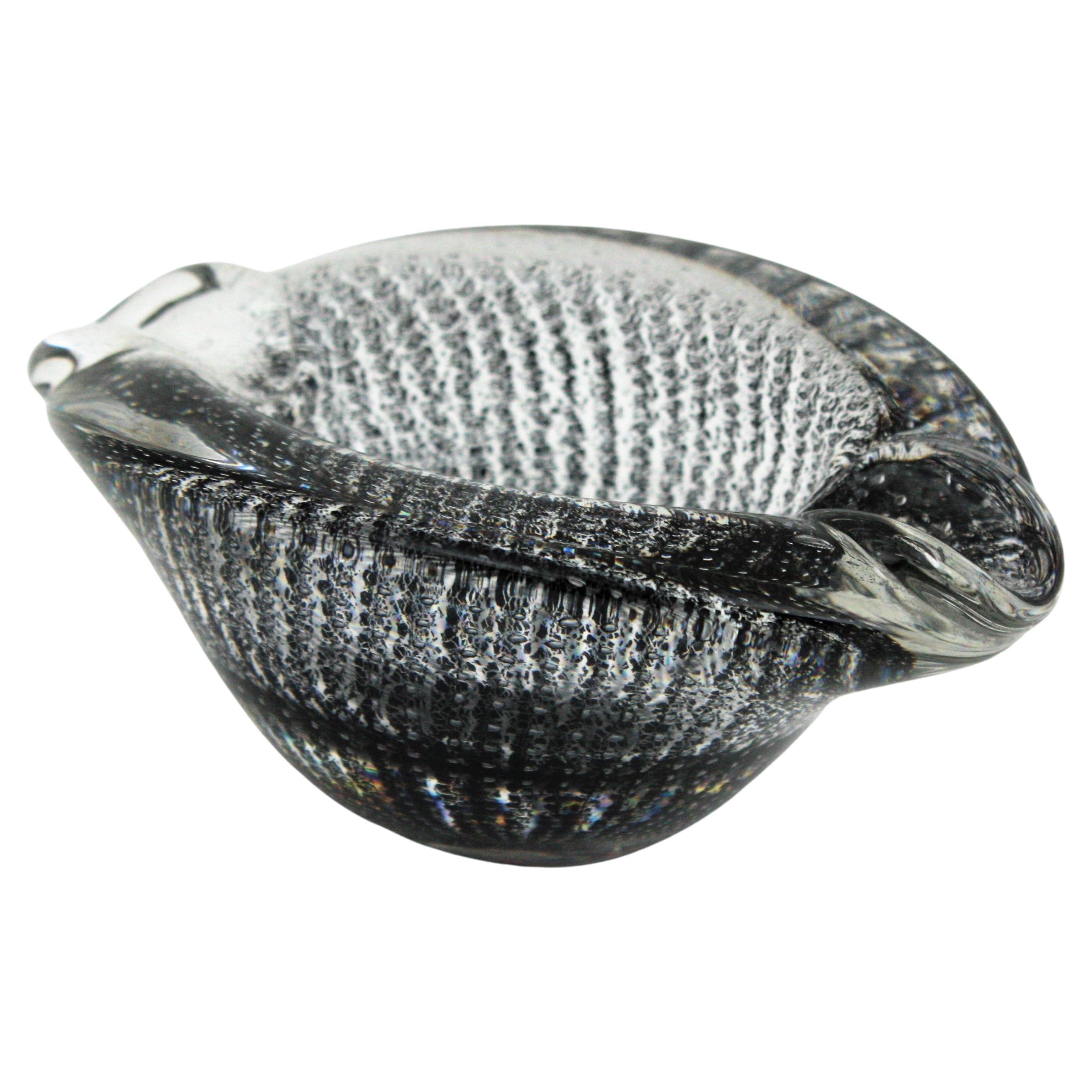 Gestreifter Bullicante Murano Aschenbecher aus Klarglas mit schwarzen Einschlüssen. Wird Archimede Seguso zugeschrieben. Italien, 1950er Jahre.
Diese auffällige Murano-Glasschale bzw. dieser Aschenbecher ist aus klarem Glas mit schwarzen Flecken