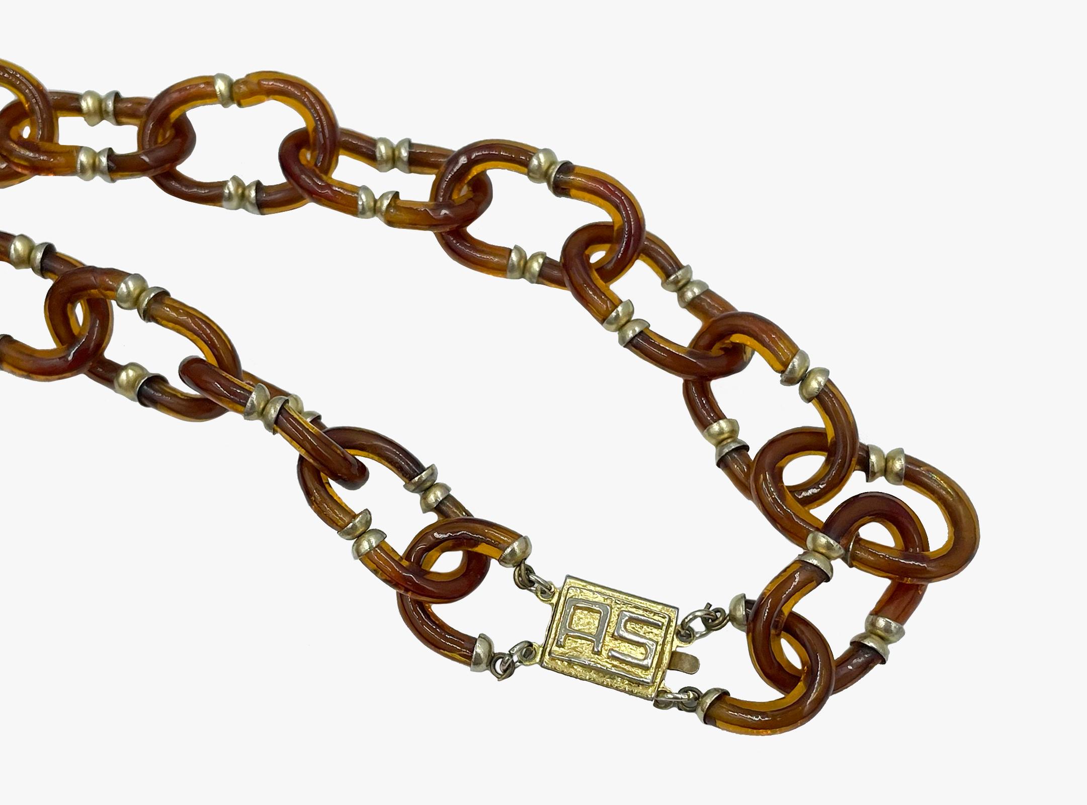 Vintage necklace designed by Archimede Seguso in collaboration with Coco Chanel. The glass “C” shape links create an interlocking Chanel CC logo.

The chain made from murano glass in brown colour. Chain links are fastened with brass and randomly