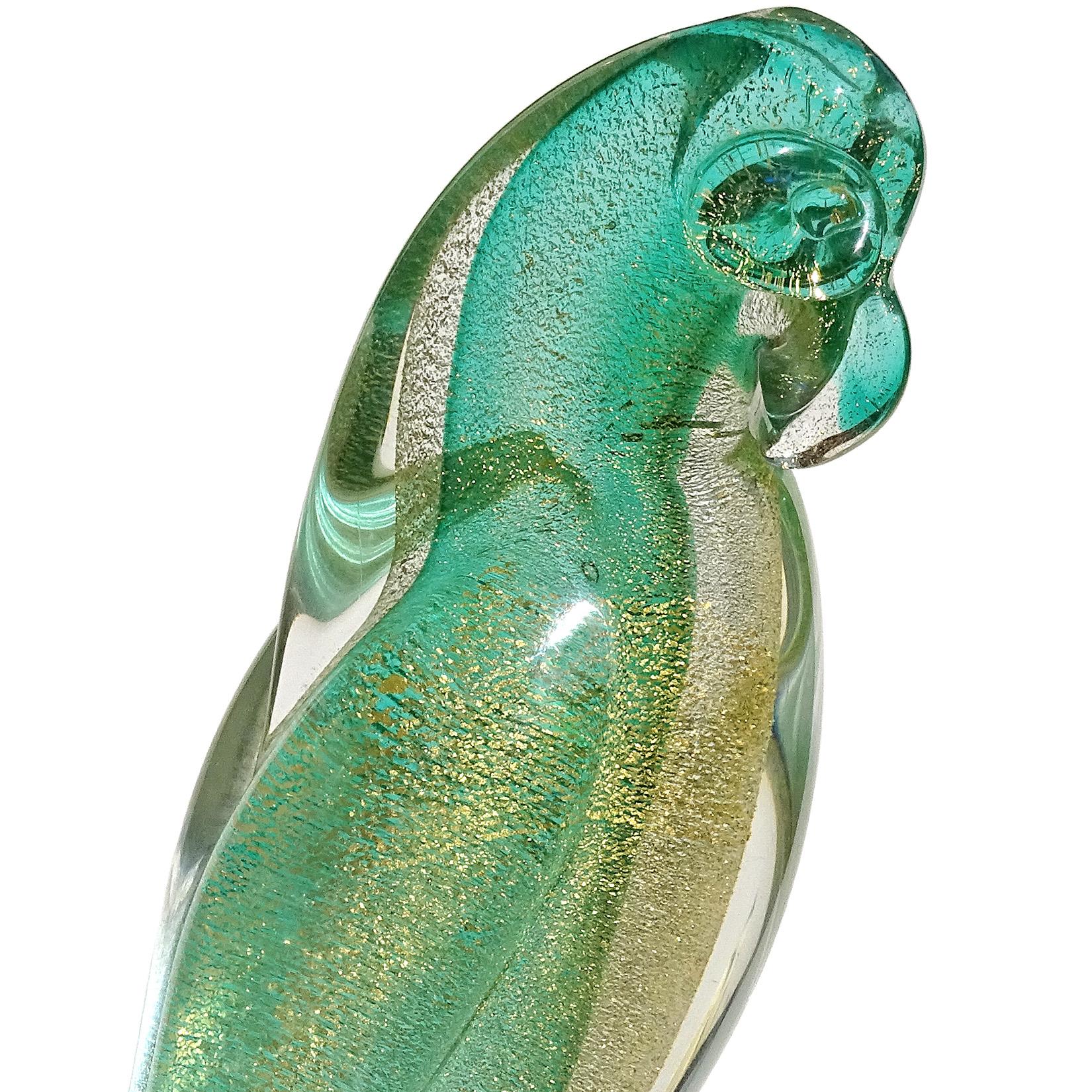 Beautiful vintage Murano hand blown, green and gold flecks Italian art glass parrot bird sculpture. Documented to designer Archimede Seguso. The bird stands on a clear pedestal, with organic shaped at the bottom of the base. Midcentury era. Measures