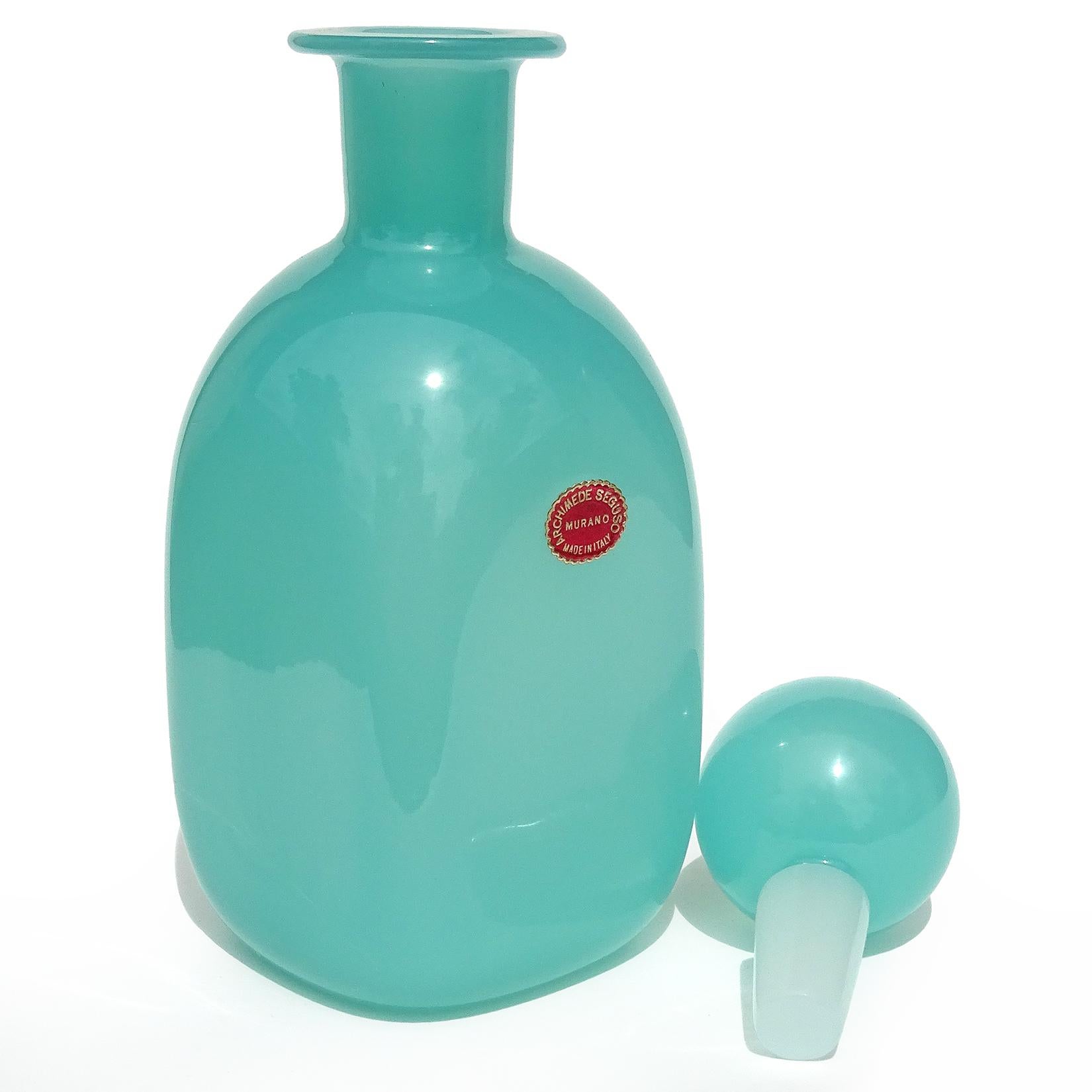 Beautiful vintage Murano hand blown opalescent Tiffany / teal blue Italian art glass decanter bottle, with original stopper. Documented to designer Archimede Seguso. It has 3 original labels still attached, including an 