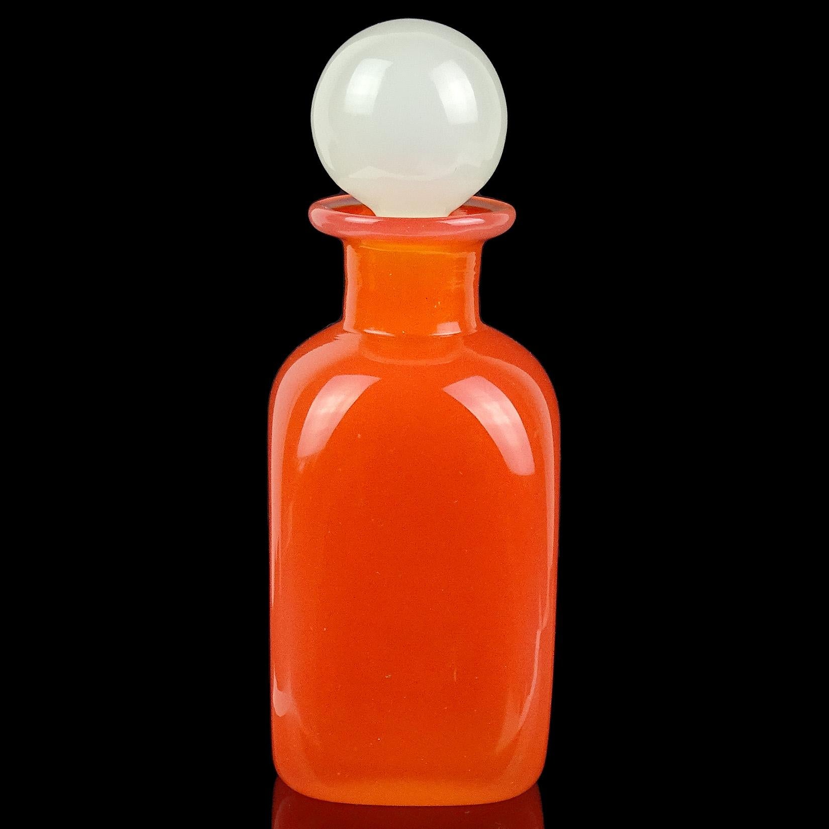 Beautiful Murano hand blown orange opalescent with white opal stopper Italian art glass decanter / bottle. Documented to designer Archimede Seguso. It has 2 original labels still attached, including 
