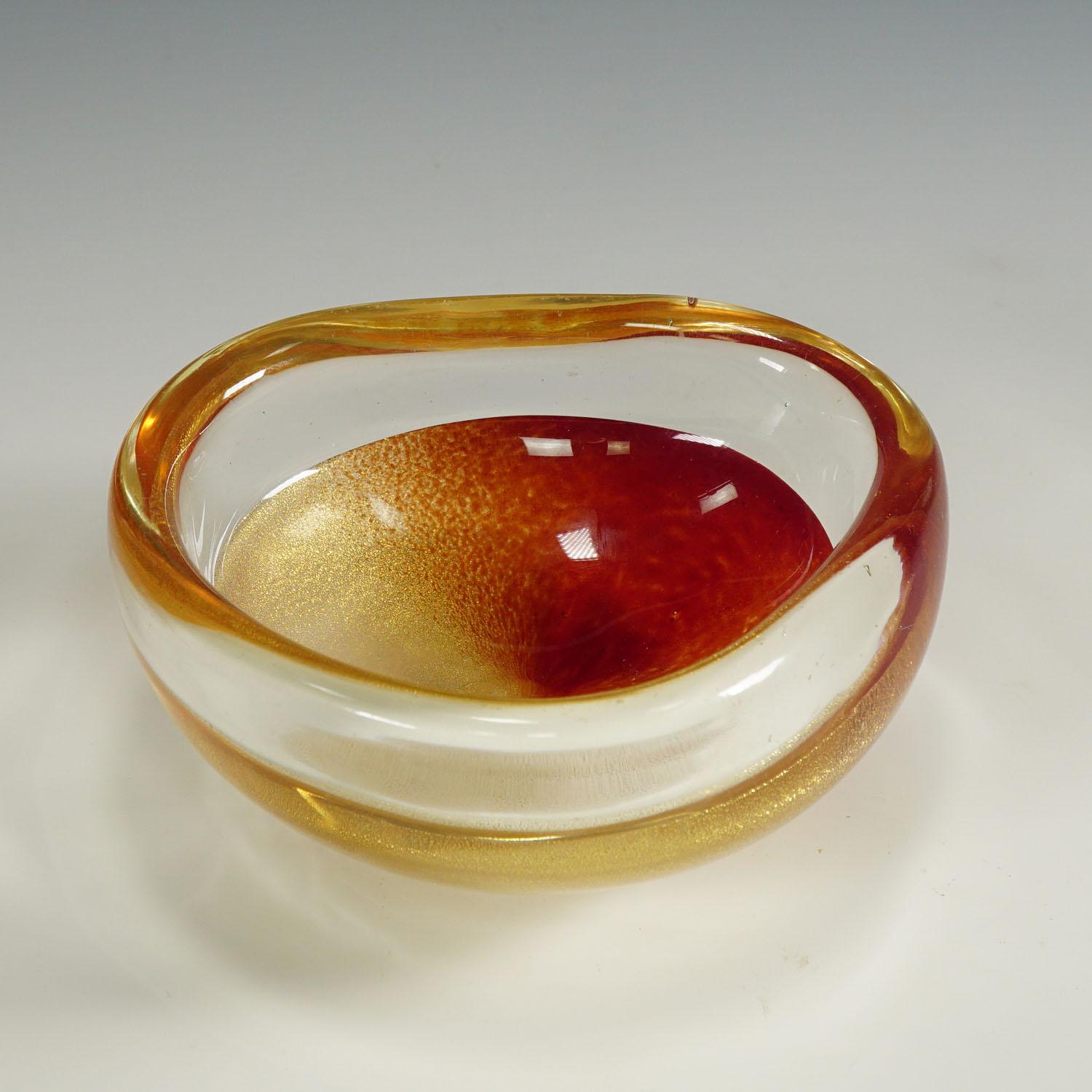 Archimede Seguso Murano Polveri Bowl 1950s

A rare venetian art glass bowl of the Polveri series introduced by Archimede Seguso in 1953. Thick clear glass with gold-speckeled and coral red glass decoration. The rim is made of crystal clear glass. An