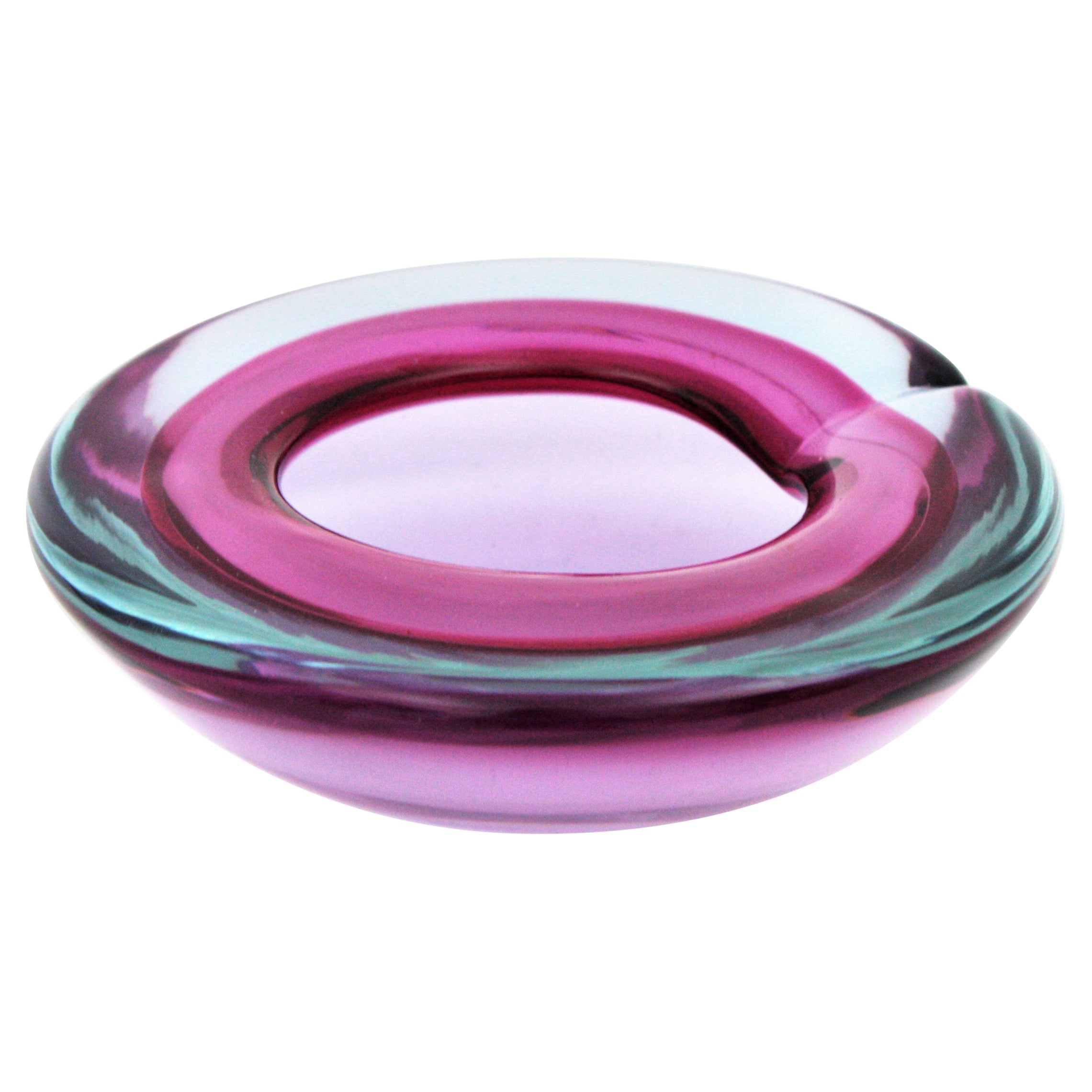 Ciotola/posacenere in vetro di Murano Glass Sommerso soffiato a mano di colore viola con bordo incamiciato in vetro rosa/blu. Design attribuito ad Archimede Seguso per la Fabbrica Seguso, Italia, anni '60.
Una ciotola rotonda in geode molto