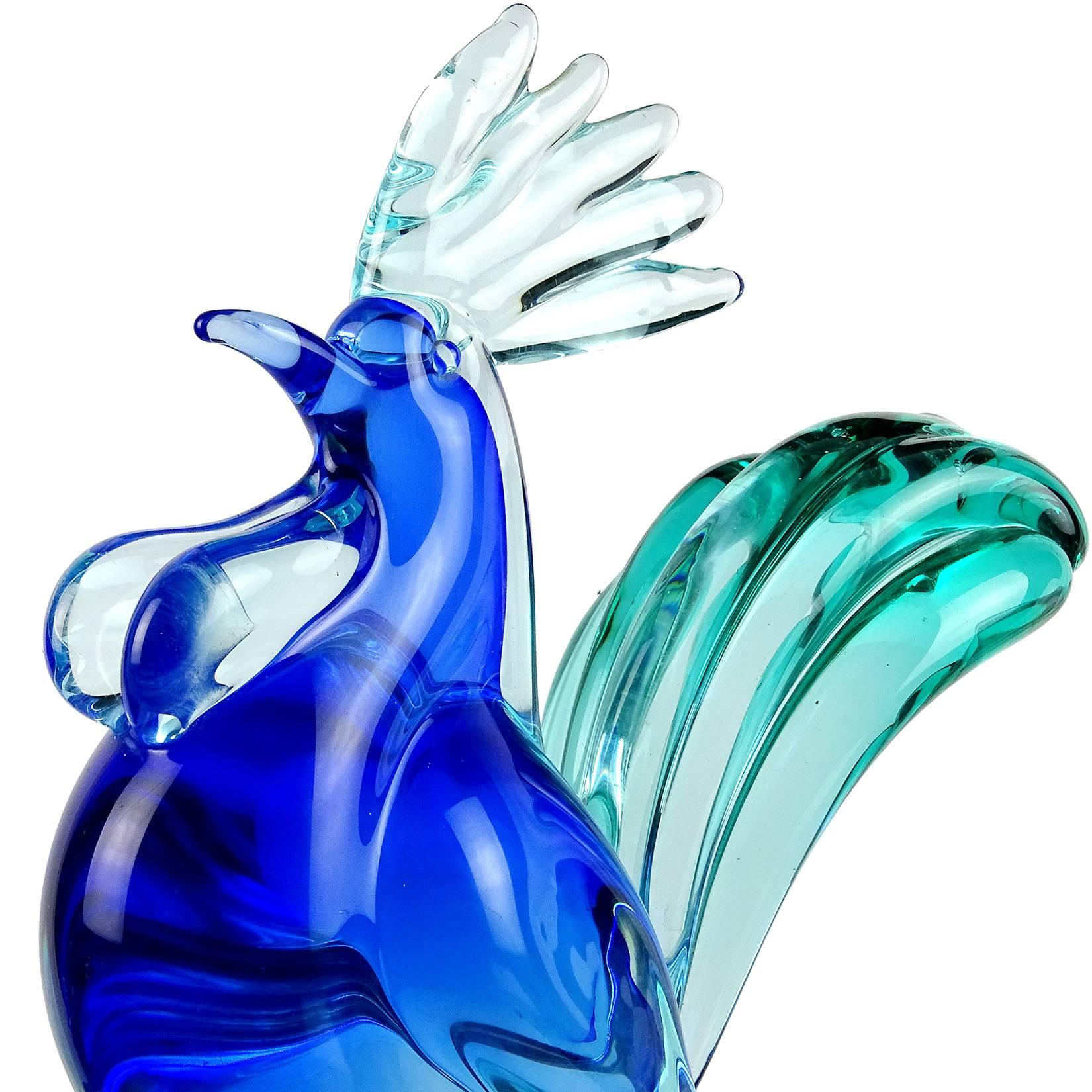 Beautiful Murano hand blown, Sommerso cobalt blue, light blue and green Italian art glass rooster sculpture. Documented to designer Archimede Seguso. The bird stands proudly, with large comb, pushed out chest and elegant tail. The base has two leafs