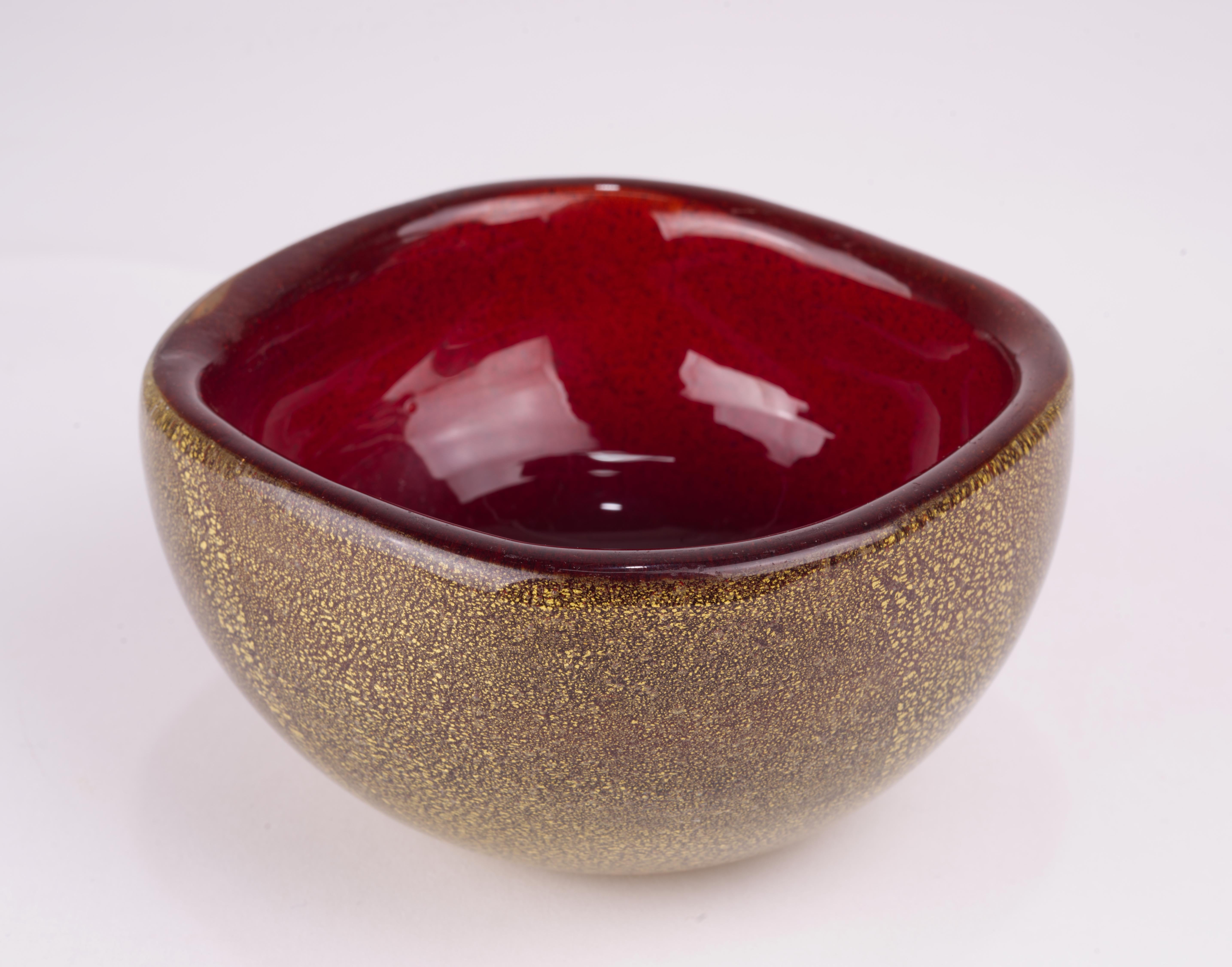  Magnificent 1950s Archimede Seguso Murano hand blown glass bowl was made in a stunning combination of deep red glass with gold leaf inclusions encased in clear glass overlay, using  polveri and sommerso techniques.

The bowl is unmarked, but the