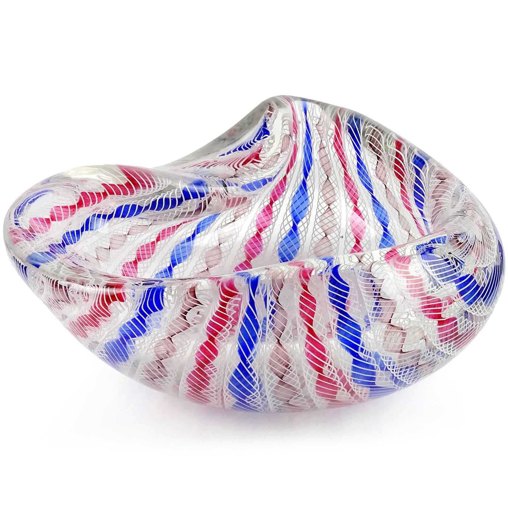 Beautiful large Murano hand blown Zanfirico twisted ribbon Italian art glass bowl. Documented to designer Archimede Seguso, circa 1950s. Has pink, blue and purple twisted ribbons, with twisted white net over them. Has a biomorphic shape and very