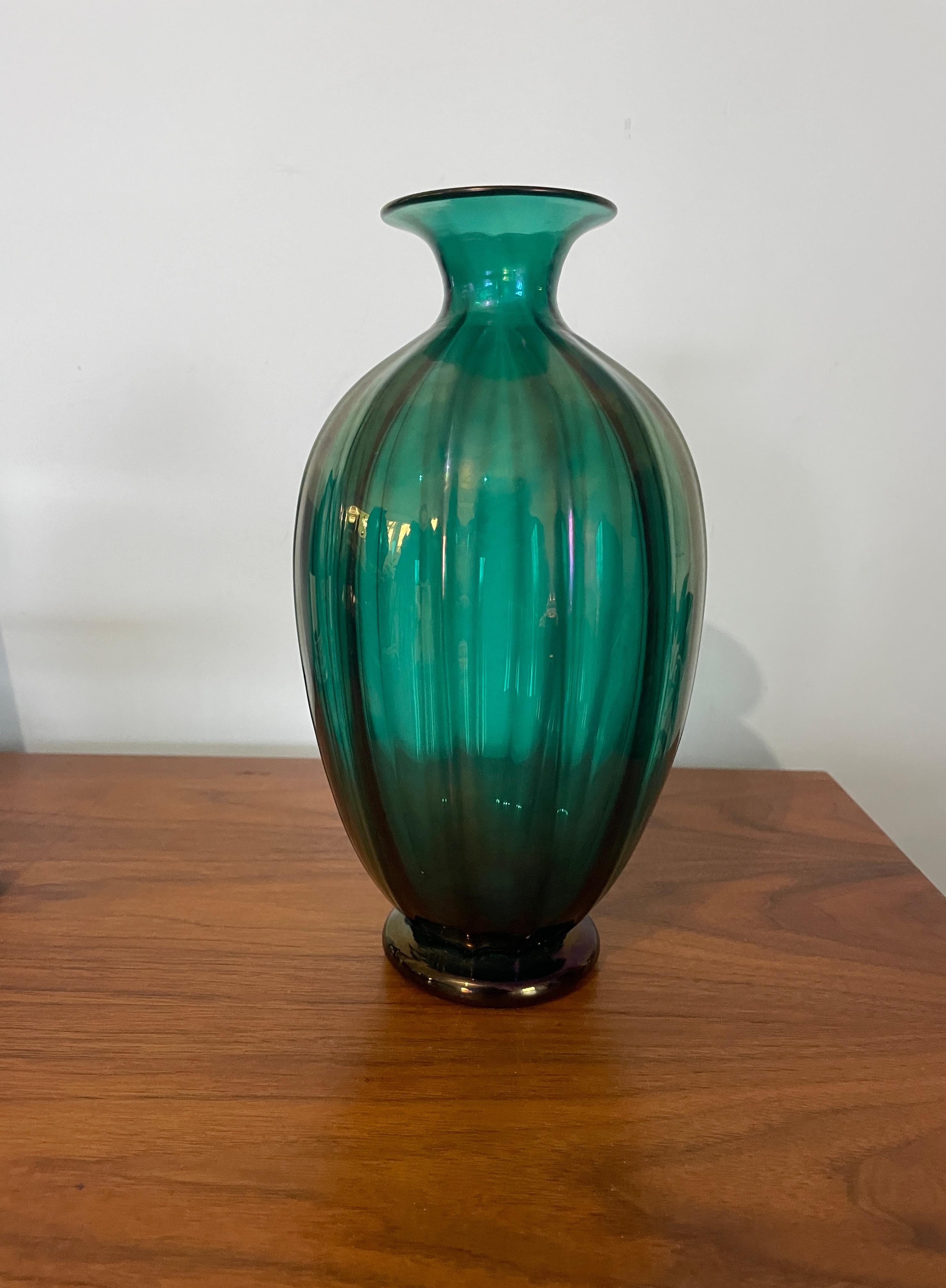 Ce magnifique vase d'Archimede Seguso présente des irisations nervurées dans une étonnante nuance de vert, ce qui en fait un ajout parfait à toute collection d'objets décoratifs. Le vase a été fabriqué avec beaucoup de soin et d'attention aux
