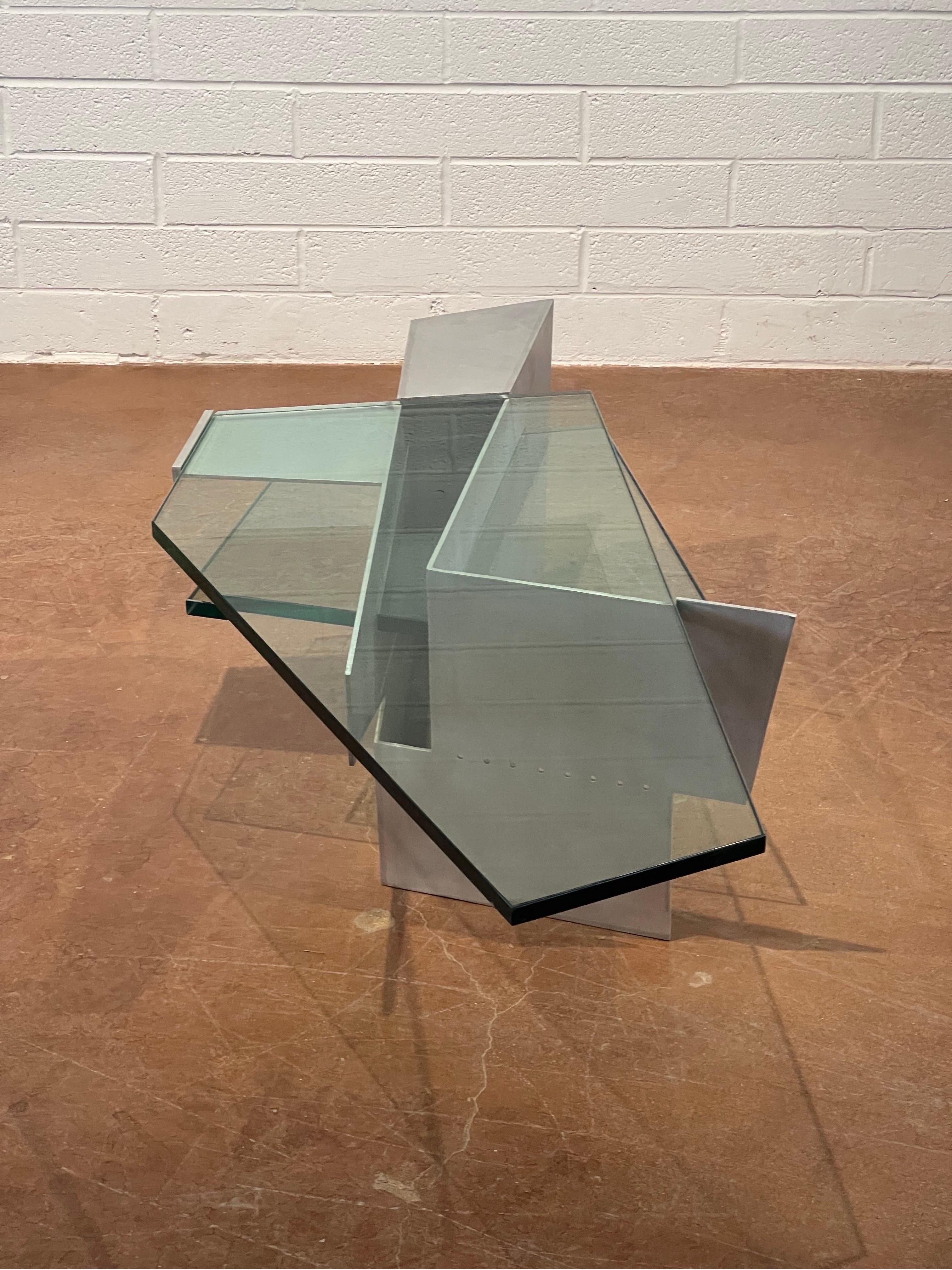 This Robert Whitton coffee table, crafted from aluminum and glass, is a striking example of design excellence from the late 20th century. Produced during the 1980s and early 1990s, the table exemplifies the era's innovative use of industrial