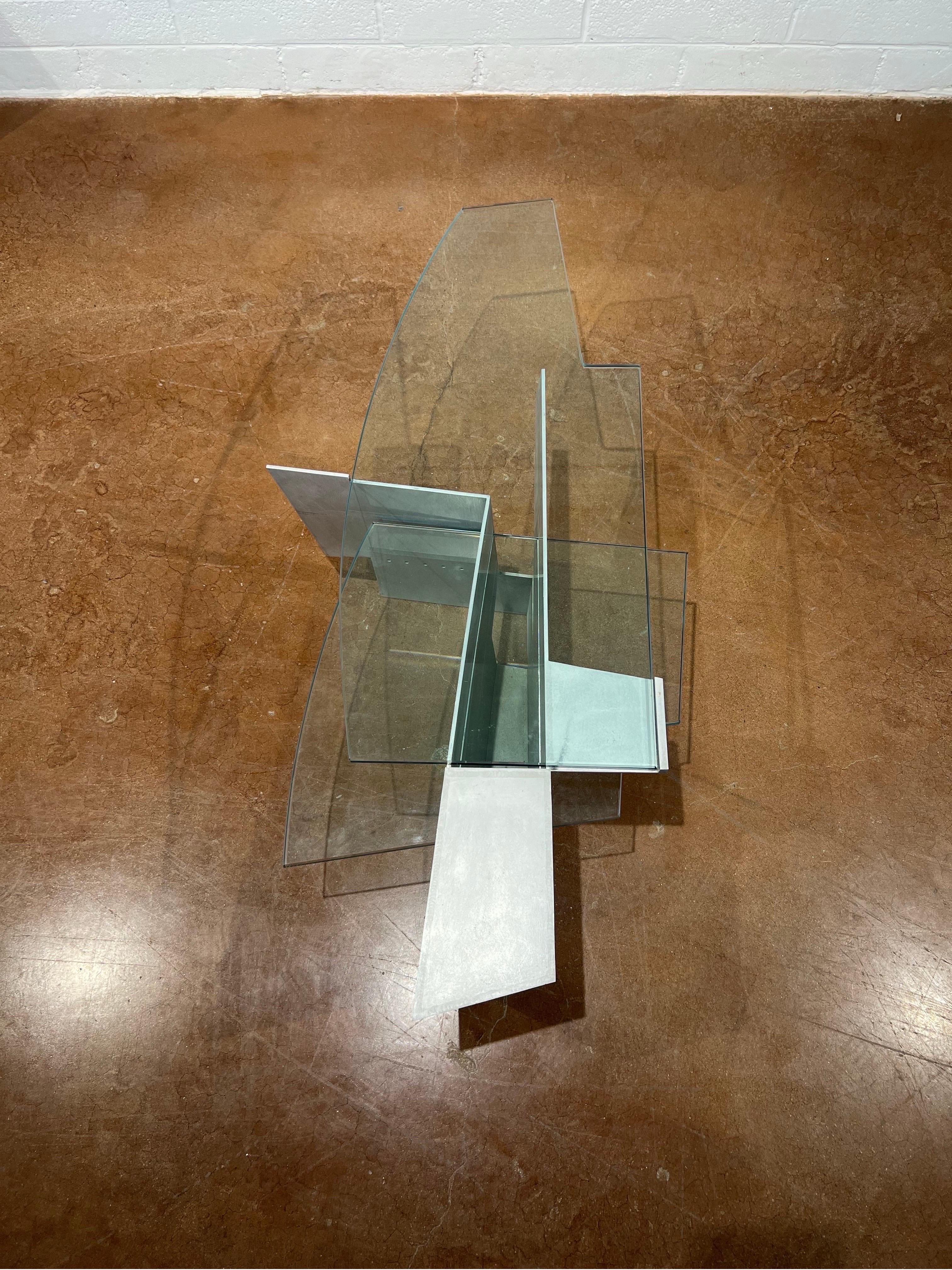 Questo tavolino Robert Whitton, realizzato in alluminio e vetro, è un esempio di eccellenza del design della fine del XX secolo. Prodotto negli anni '80 e nei primi anni '90, il tavolo esemplifica l'uso innovativo dei materiali industriali nel
