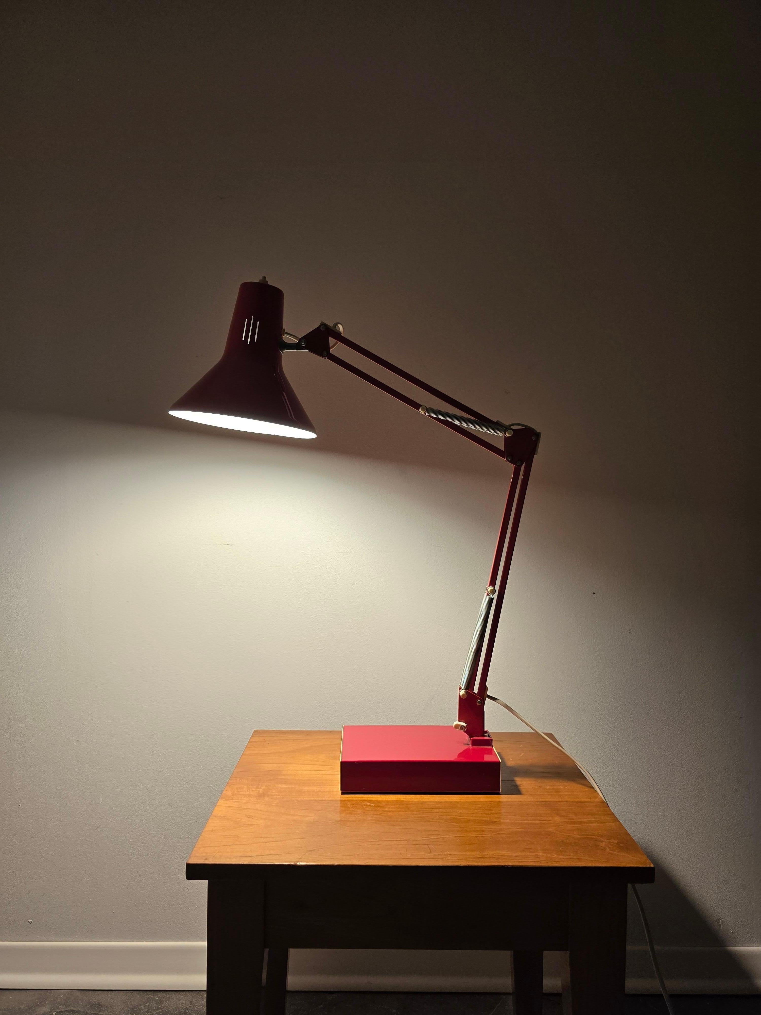 This stunning 1970s red architect table lamp by Arteluce features a sleek metal design with a double-articulated arm and an adjustable shade for precise, targeted lighting. Made in Italy, the lamp is in very good original condition and functions