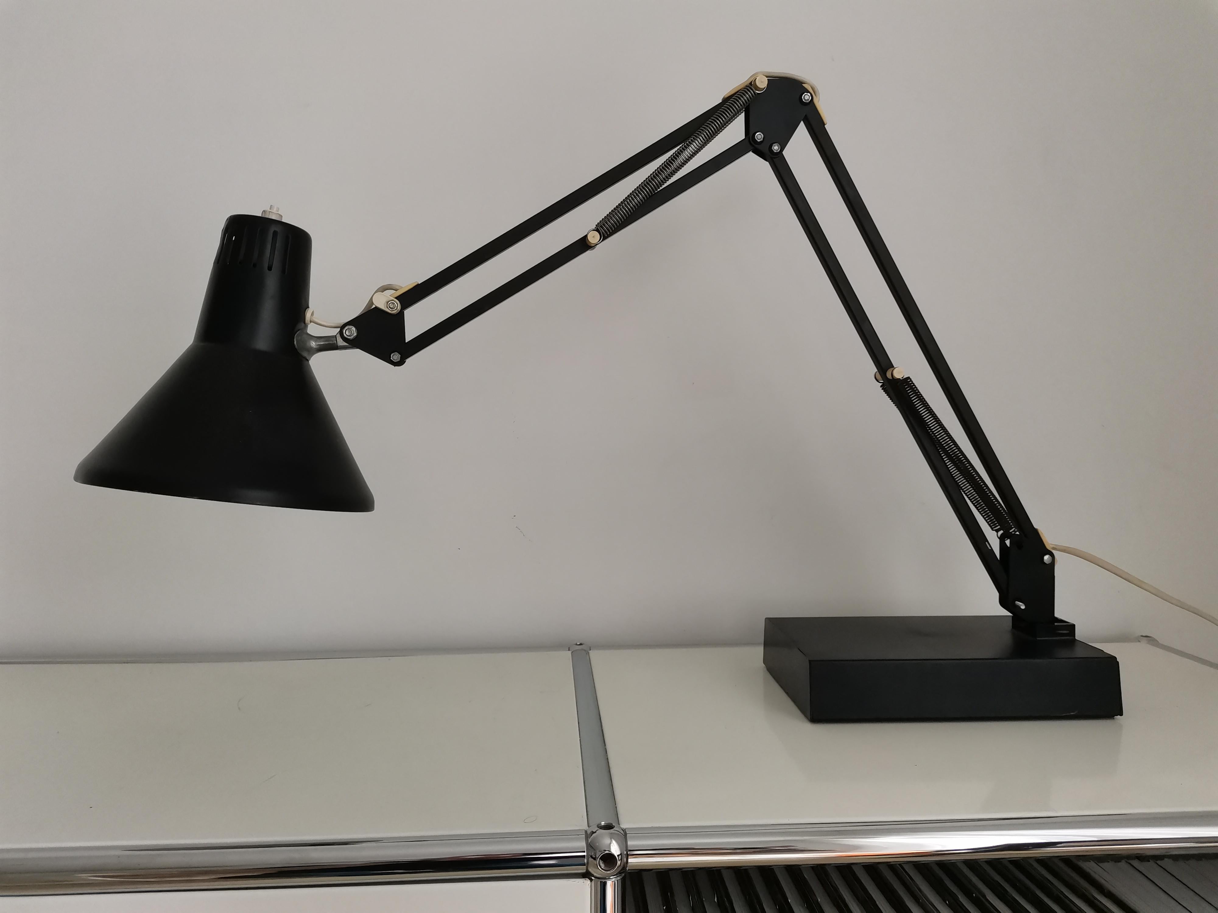 This stunning 1970s black architect table lamp by Arteluce features a sleek metal design with a double-articulated arm and an adjustable shade for precise, targeted lighting. Made in Italy, the lamp is in very good original condition and functions