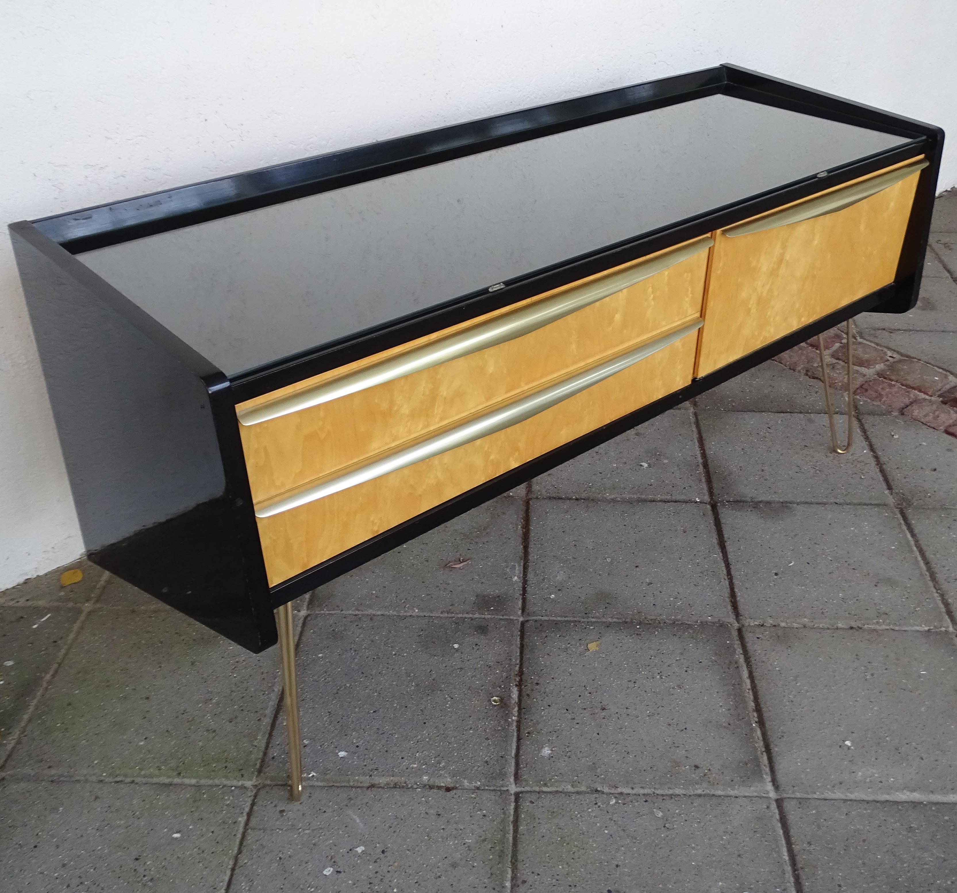 Midcentury sideboard manufactured by Vereinigte Werkstätten, Munich, around 1955, Very unusual design featuring asymmetrical side panels and a duo tone finish of black lacquer and (probably) apple or pear veneered wood. The sideboard features two