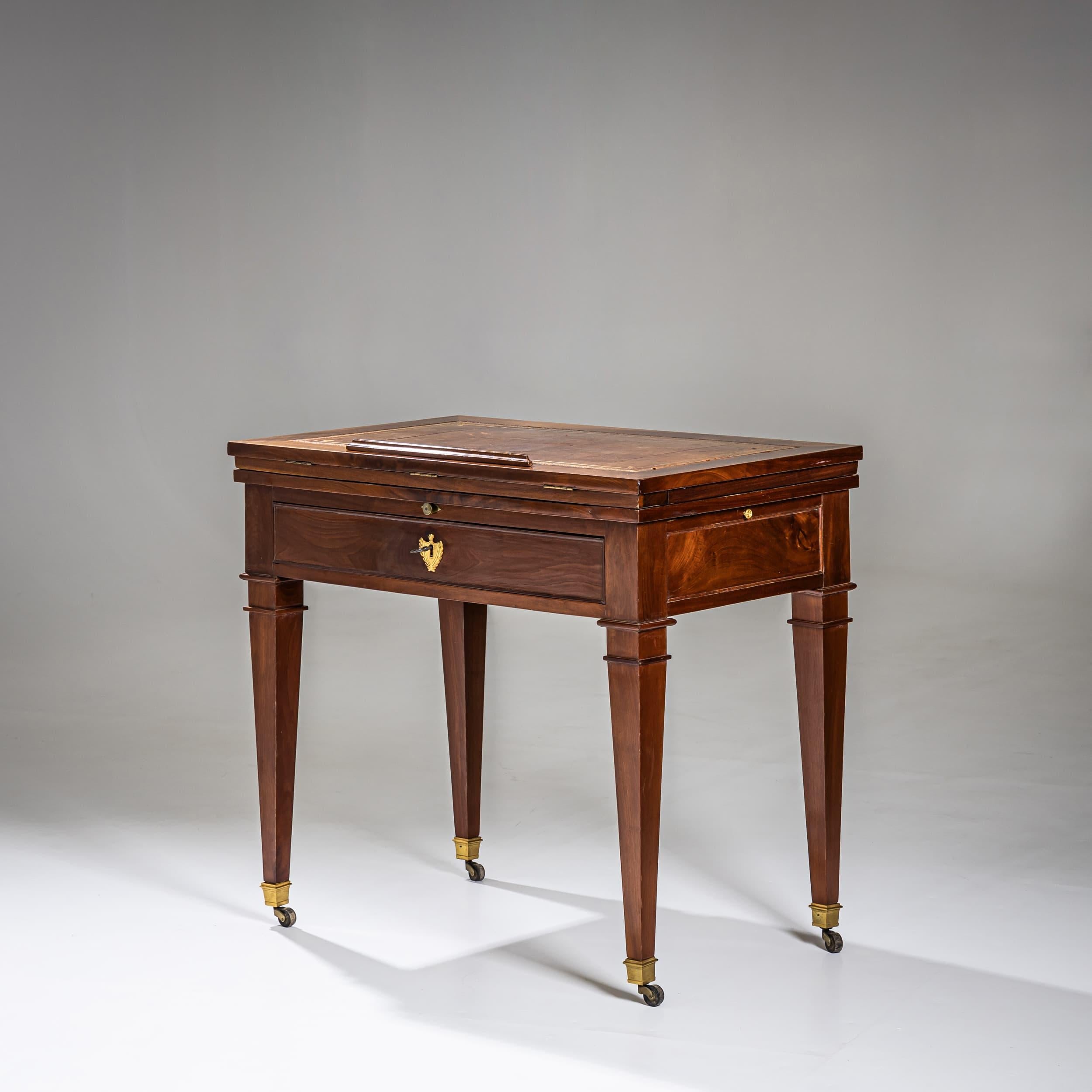 Rara scrivania da architetto in stile à la Tronchin, dotata di una superficie di scrittura ad altezza regolabile e due vassoi laterali estraibili, tutti rivestiti in pelle marrone. Un ampio cassetto sotto il piano offre un pratico spazio di