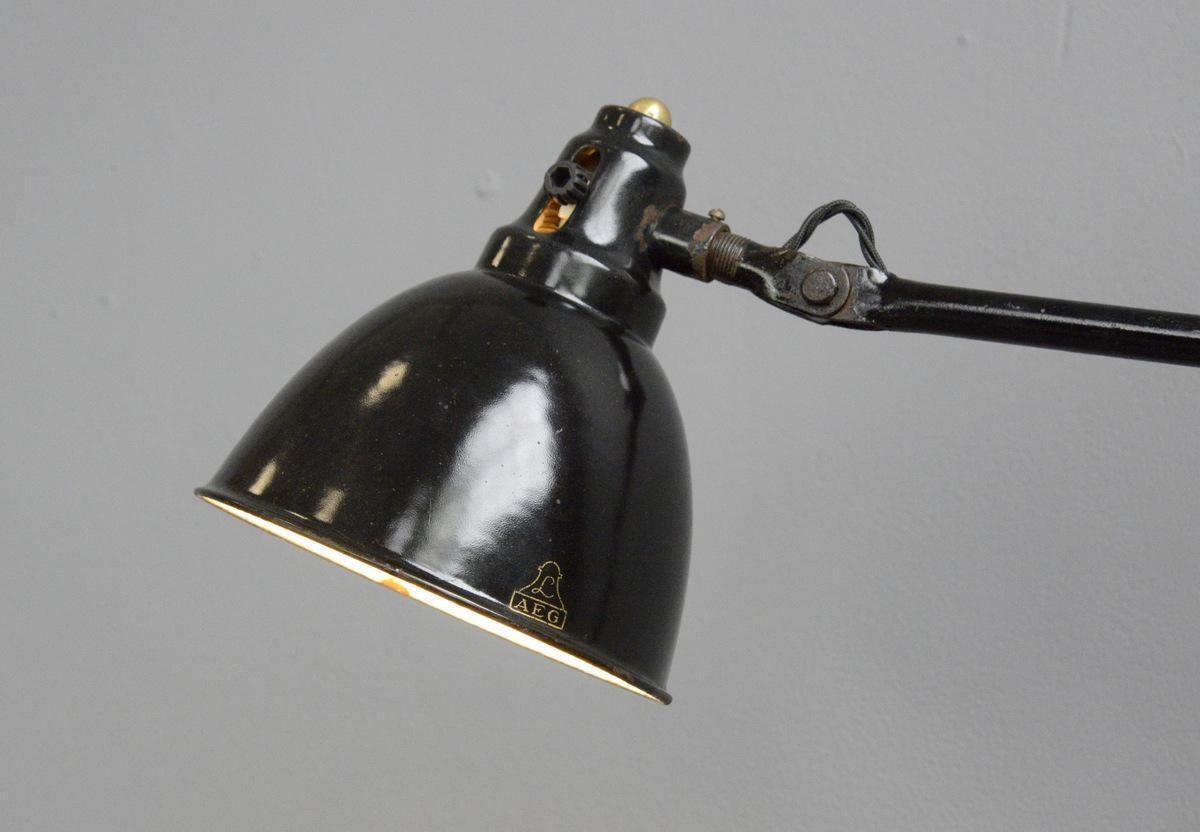 Architektenlampe von Peter Behrens für AEG, um 1920

- Schwarzer glasierter Emaille-Farbton
- Gelenkte Stahlarme
- Ein/Aus-Kippschalter an der Blende
- Für E27-Glühbirnen geeignet
- Entworfen von Peter Behrens für AEG
- Deutsch, 1920er