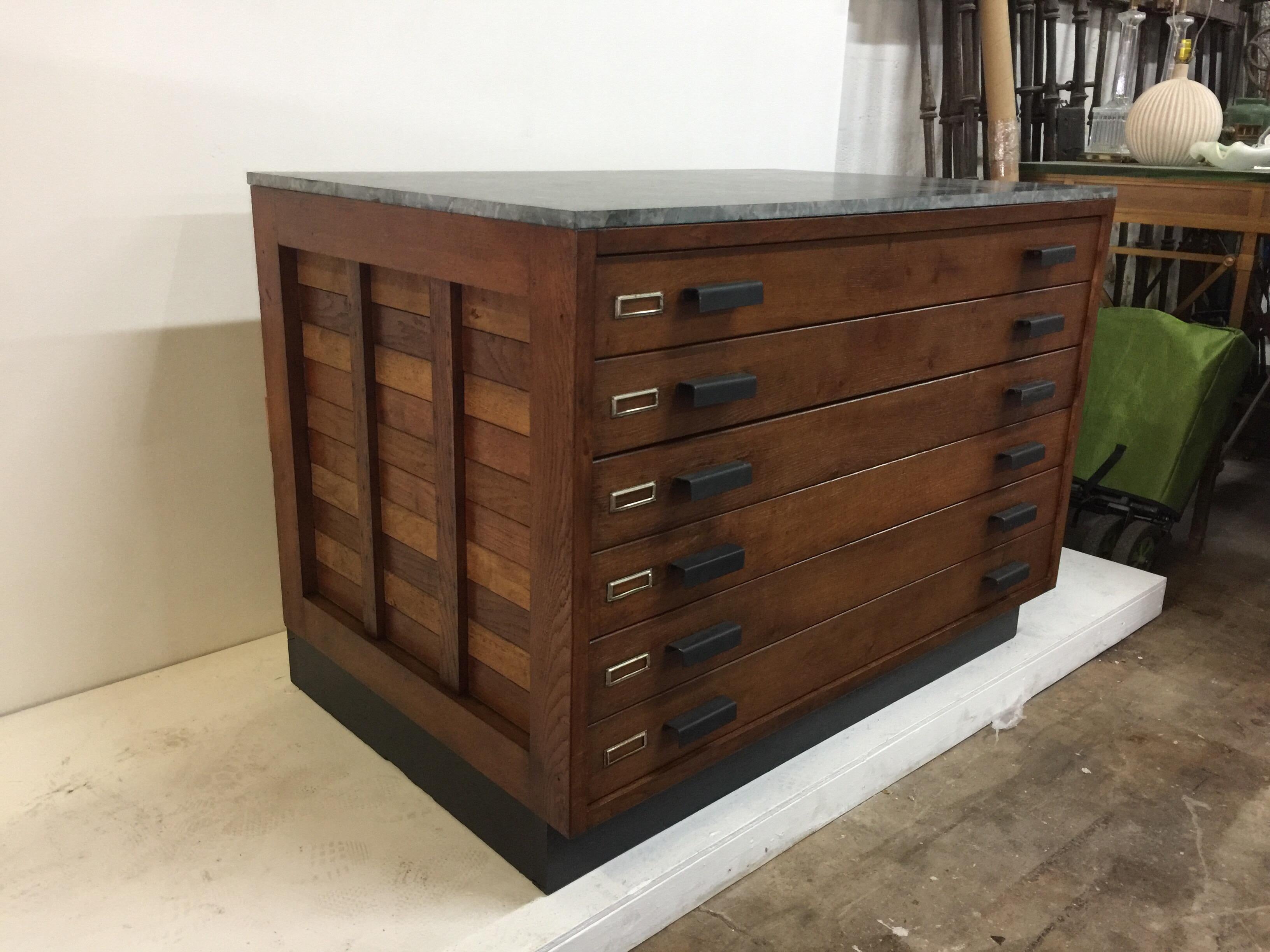 This extraordinary Industrial oak cabinet with all original painted black metal pulls and label holders. This cabinet has a petrified wood top with wonderful details. Black wood base floater - 6 large drawers, glide easily to open. This cabinet has