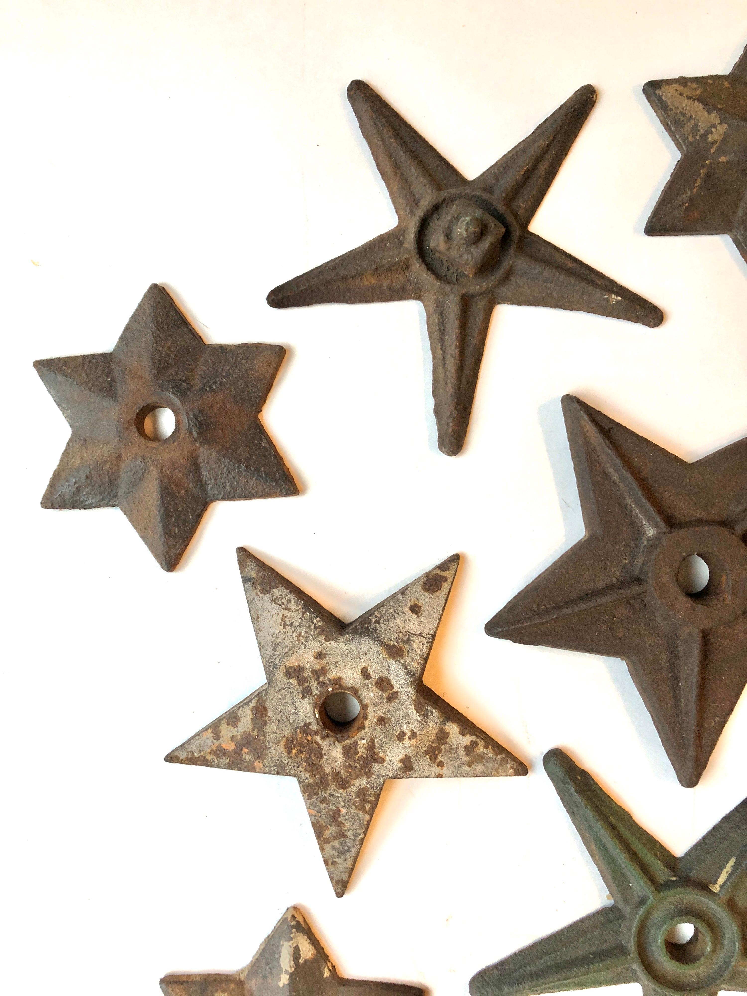 A collection of 11 19th century antique cast iron decorative star shaped building supports. Used in early brick building construction. Support rods would run the width of a building capped off at the outside with a decorative shaped star. This