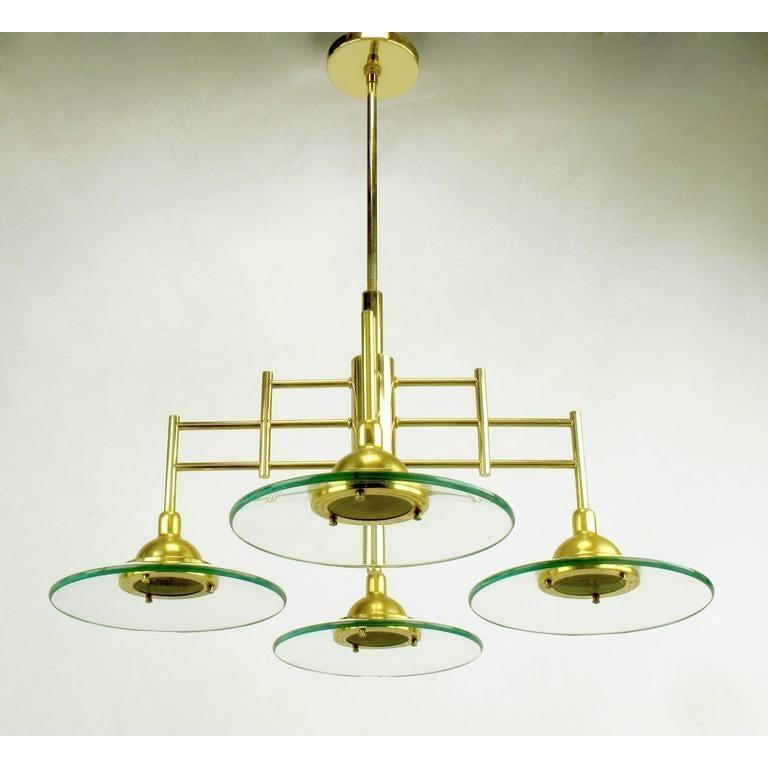 Brass four-light pendant chandelier with thick glass plate shaped shades. The glass shades magnify the amount of light making this a brighter than expected light. The frame of this chandelier is an architectural brass four arm structure with center