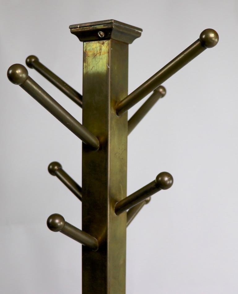 Nice turn of the century brass coat rack, tree stand. This example is unusual in its Modernist, architectural style and design, reminiscent of Aesthetic Movement master Christopher Dresser. The top has 8 hangers, the upper arm is a bit longer (5.5