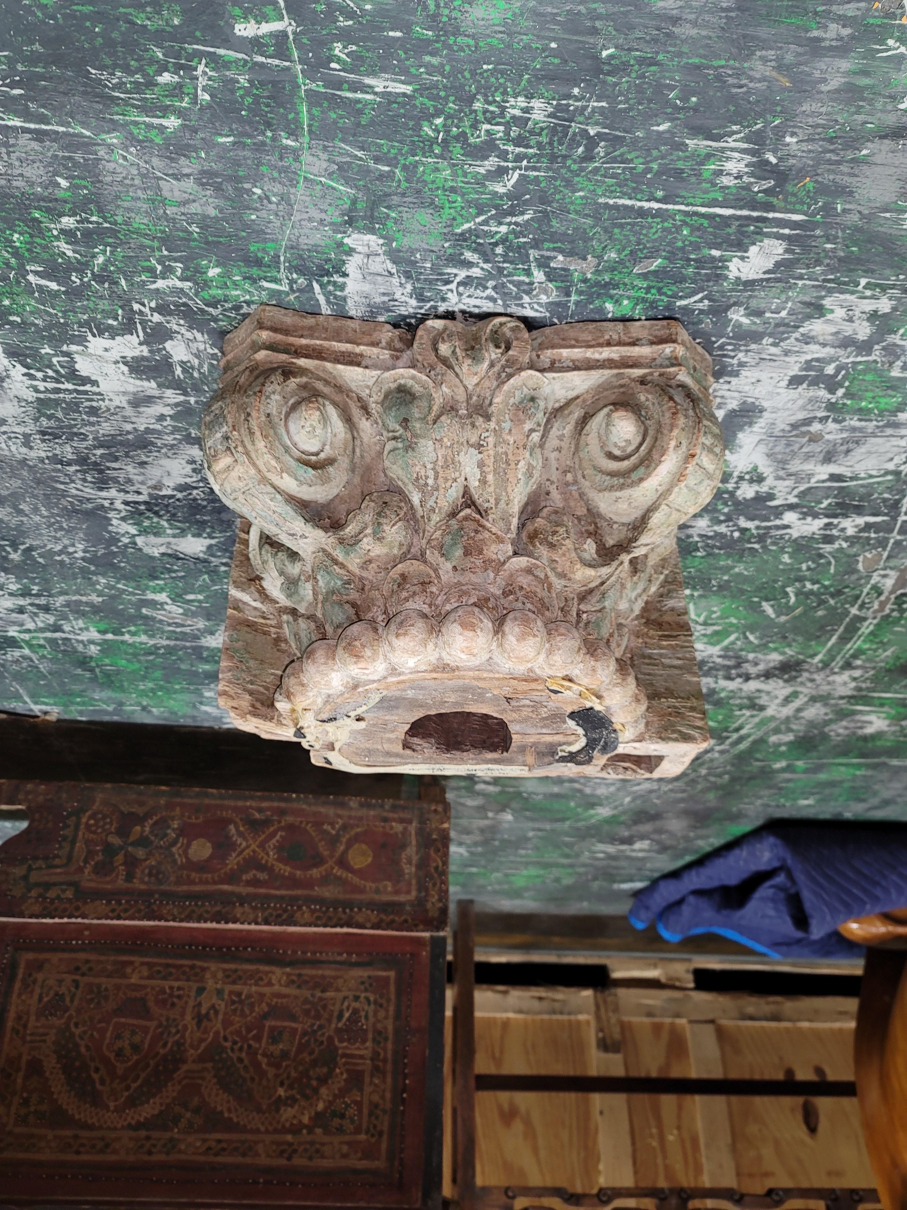 Architectural carved wood Fragment of an Ionic Capital in worn green paint. A solid piece of wood hand- carved into a beautiful ionic capital, probably early 20th Century. A beautiful decorative piece can be used to put plants on, candles, sculpture