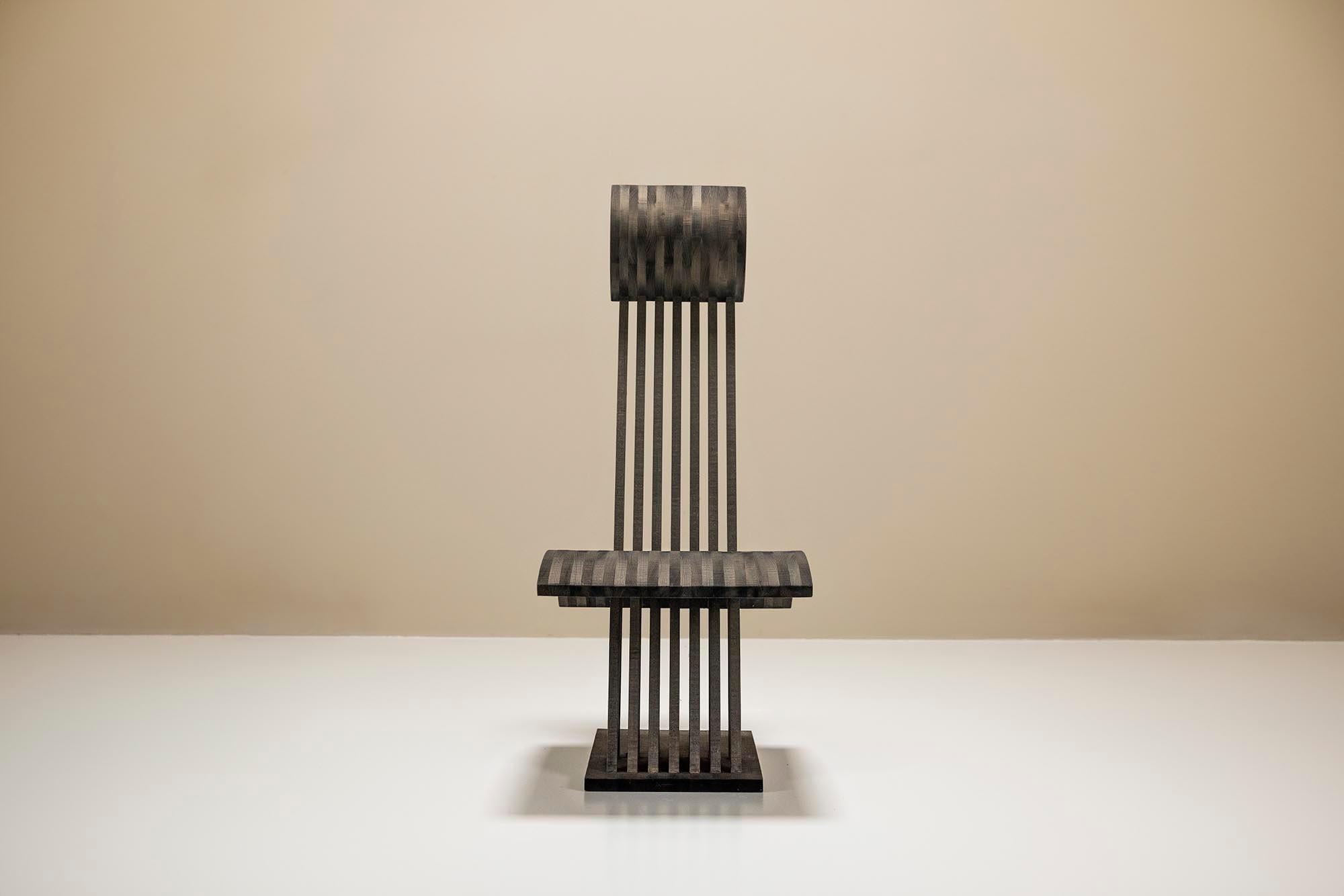 La chaise se distingue par l'utilisation de bois foncé, qui a une teinte grise et froide. Cette couleur confère à la chaise un aspect contemporain et élégant, ce qui lui permet de s'imposer dans n'importe quelle pièce. Le bois sombre contribue à une