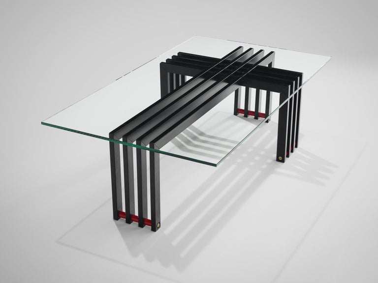 Coffee table with glass, steel, Europe, 1970s.

This sculptural coffee table with transparent glass top and geometric frame and horizontal red slats as a foot. Four iron slats bend form a cross with another four slats of metal. This sculptural