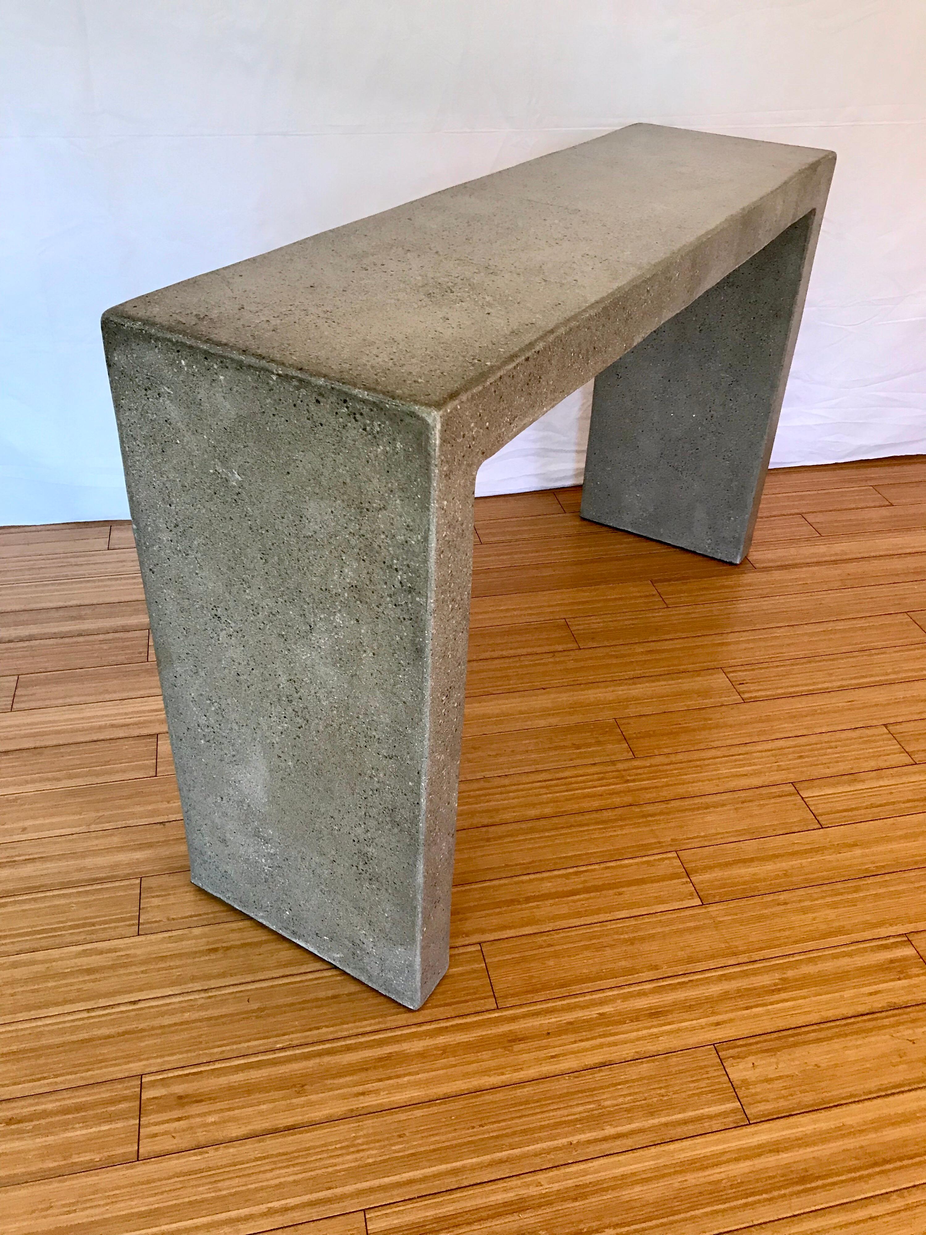 A simple and elegant form attributed to Karl Springer.
Made of cast concrete, weights roughly 200 pounds. It probably has some rebar wire inside for durability and stability.
It has a nice patina, and some surface hairline cracks (blends into the
