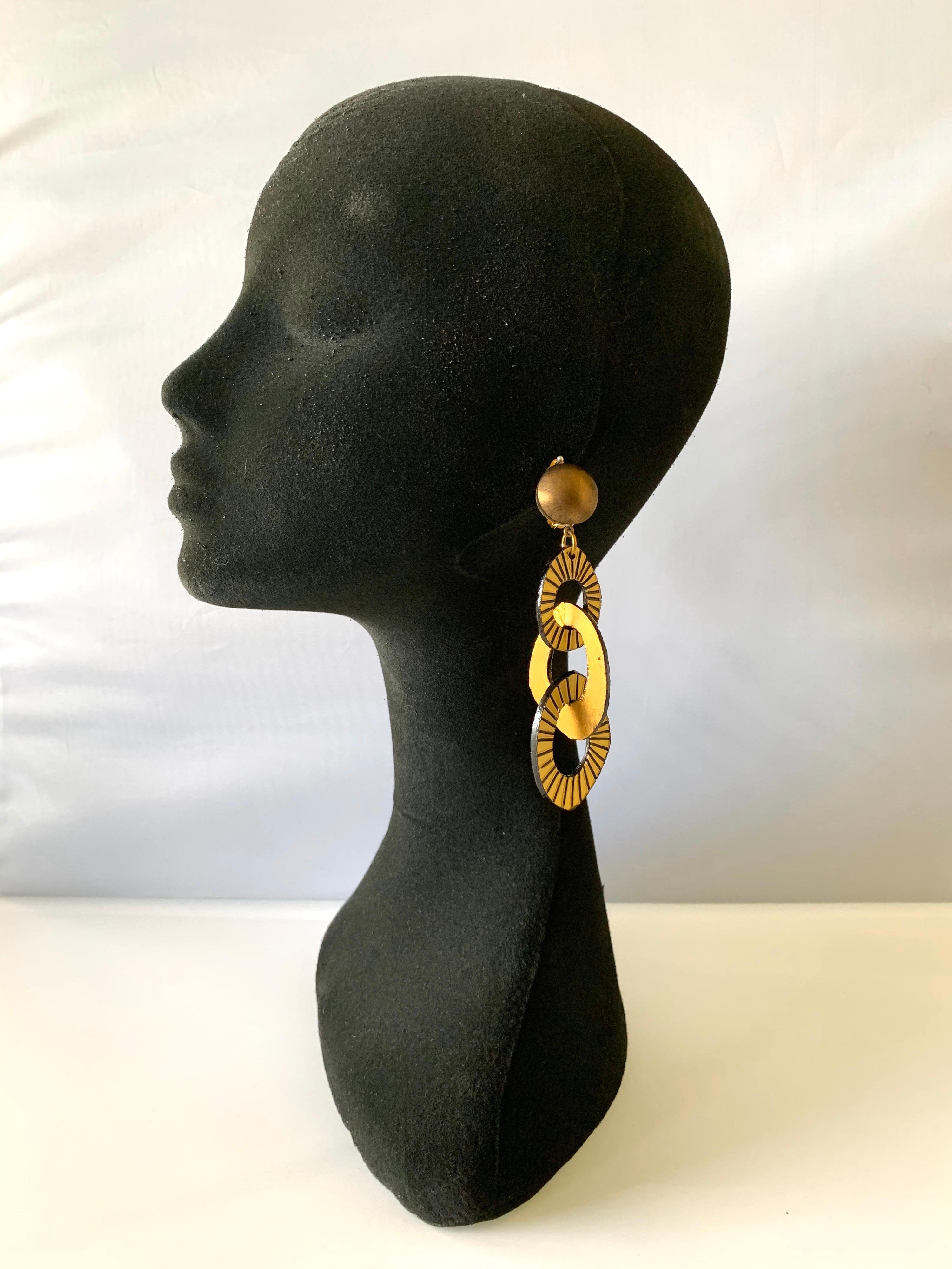 Chic and very current, these handmade fashion-forward artisanal clip-on earrings were made in Paris. The statement earrings feature three carved detailed architectural (enamel and resin composite) geometric links in bronze and gold. Lightweight and