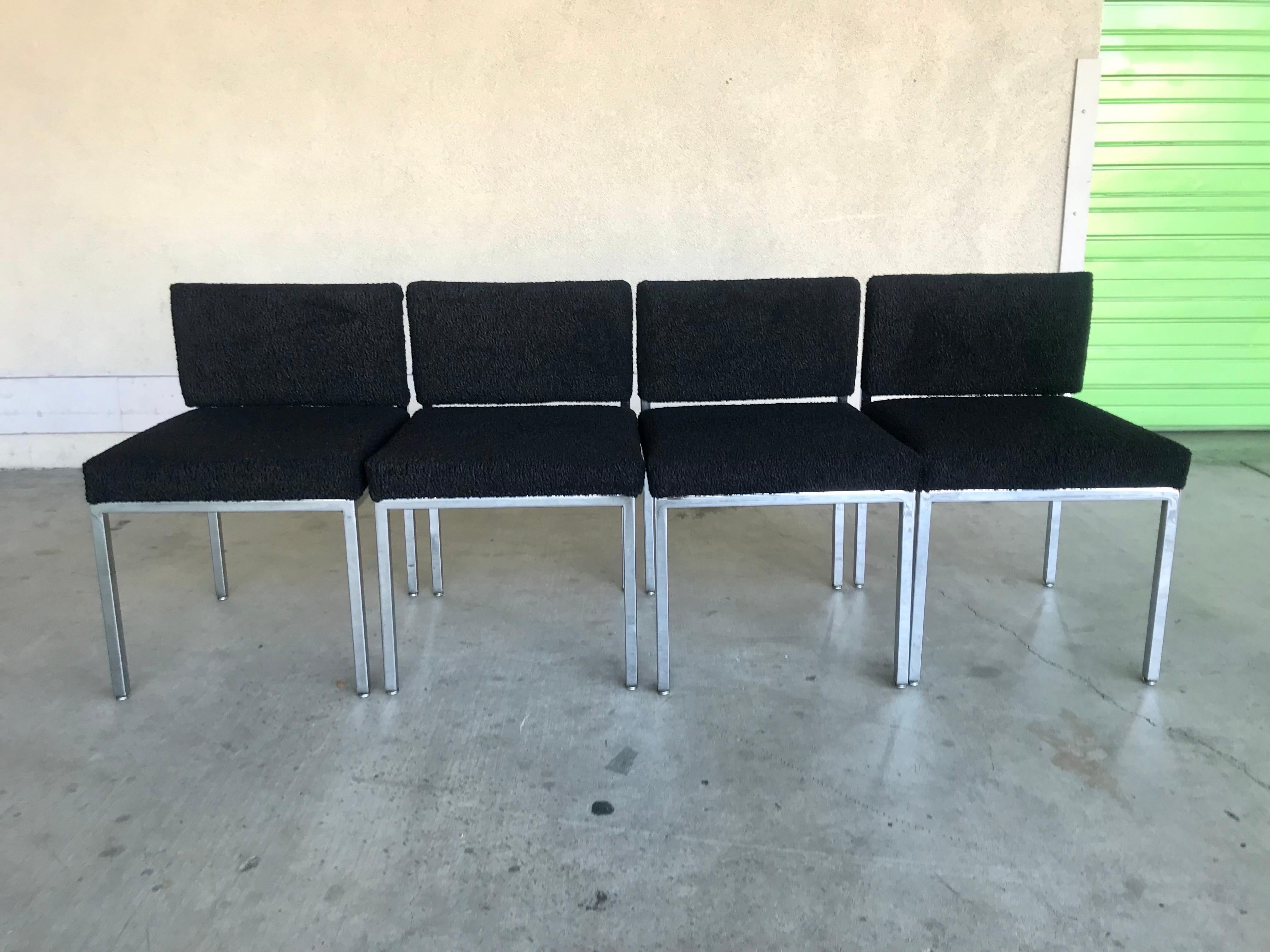 Simple modernist design. 
Great for any occasion: dining, gallery, office, breakfast nook et cetra..
Polished steel with new black boucle upholstery. 
The backrest has a nice feature. 
It contours to the sitters back pivoting back and forth for