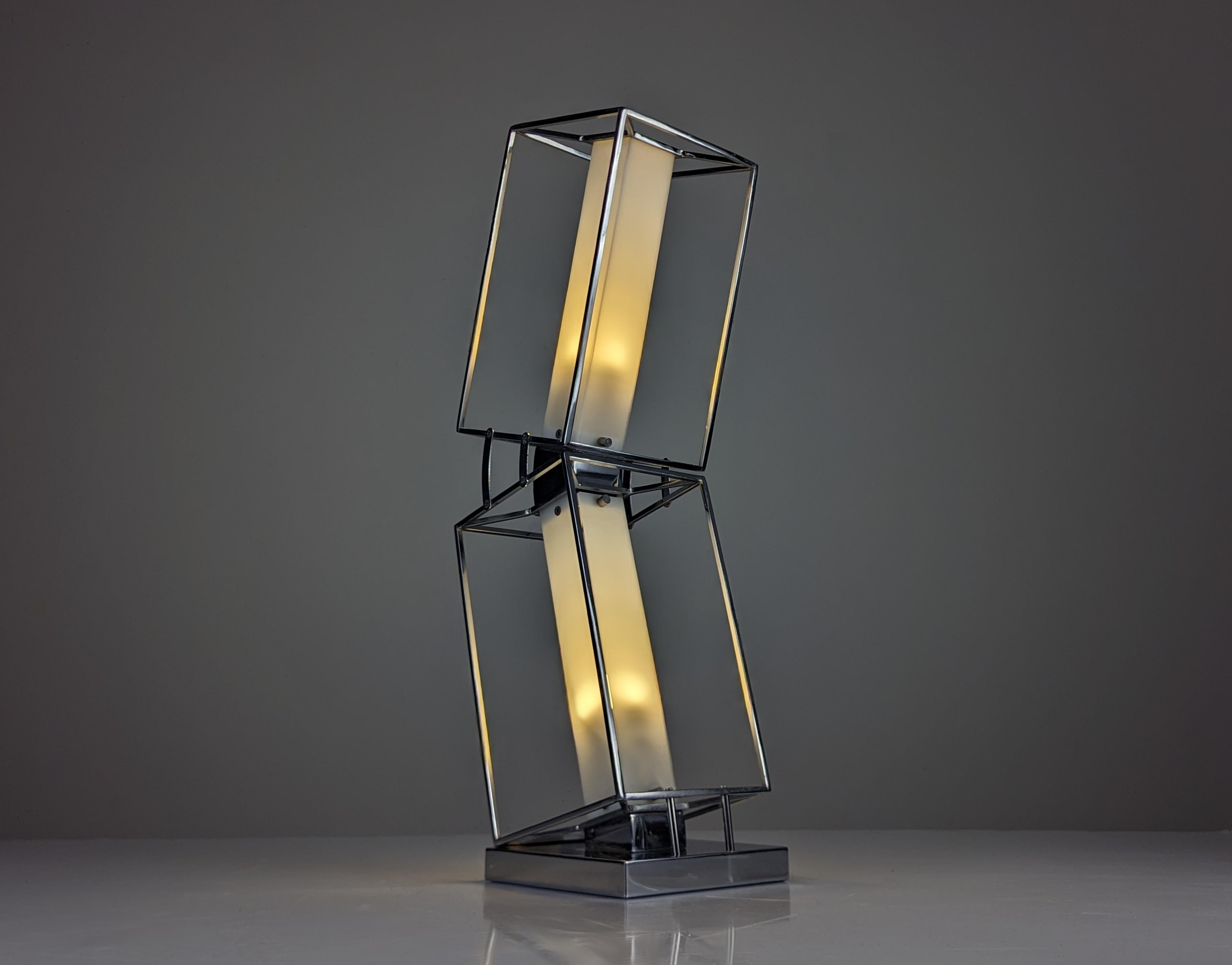 Architectural design table lamp from the 20th century, crafted in chromed metal forming two tilted cubes that create an incredible sense of movement. Inside, two points of light with white translucent acrylic diffusers rise, providing a cozy and