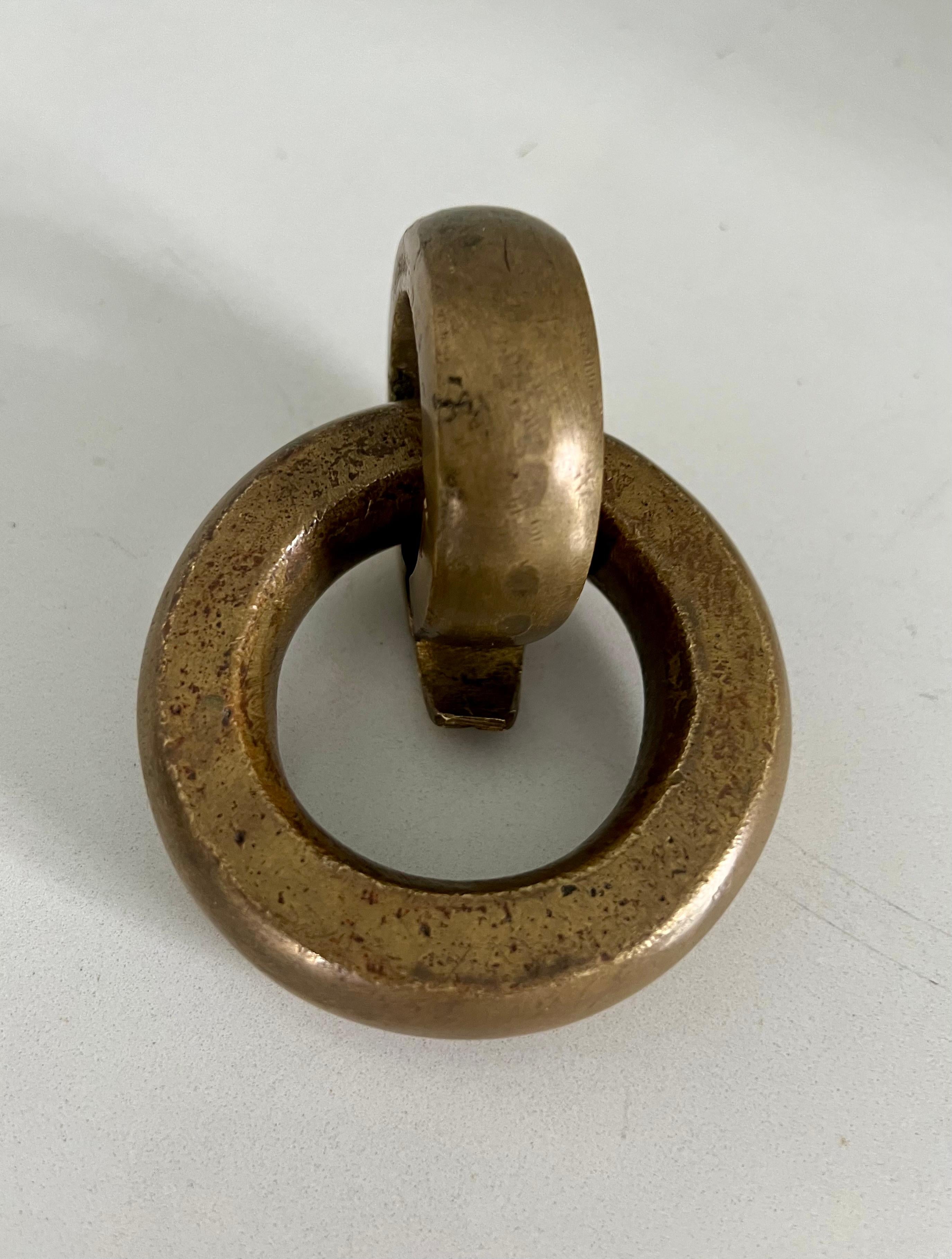 Gorgeous architectural element with good weight. This piece consists of two interlocking bronze loops. Can be used as a paperweight for mail or documents. A great piece for a home office or entry table.