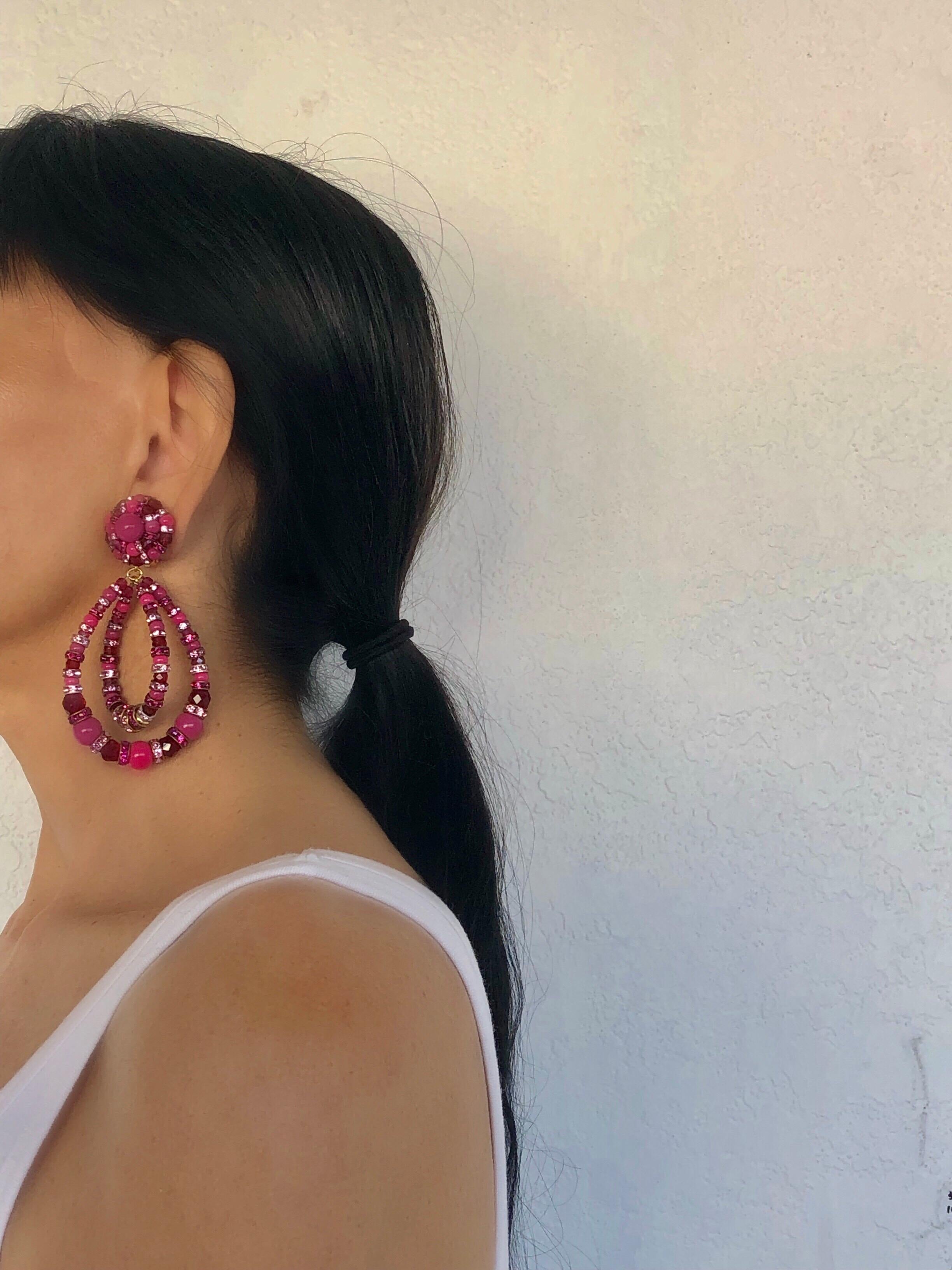 French designer architectural statement clip-on earrings made in Paris by Francoise Montague - the earrings feature  fuchsia and pale pink glass beads which are accented by a plethora of  faceted round red glass beads. What's special about the