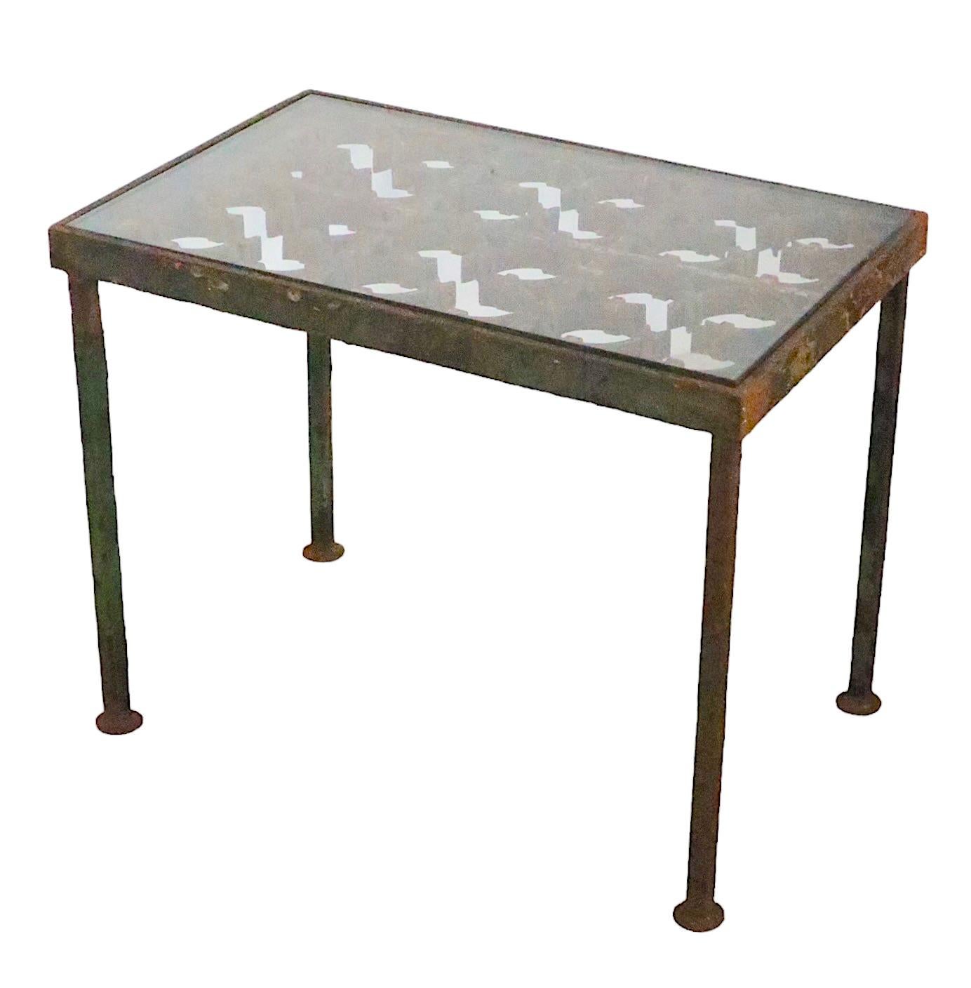 Garden, patio or poolside table constructed of a decorative cast iron panel, of classical latticework pattern, set in a steel frame, with a thick plate glass top. The cast iron panel was salvaged from a large scale building, and repurposed as a side