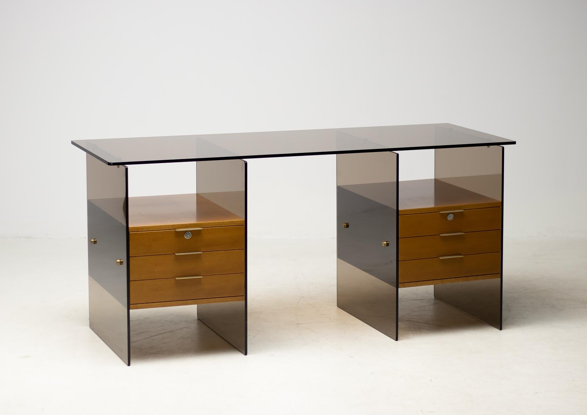 Exceptional 1960s glass desk reminiscent of the designs by Antoine Philippon and Jacqueline Lecoq for Behr.
Very high end design and very practical. The bases both have a box side and a drawers side. 
Many configurations possible.
The brass