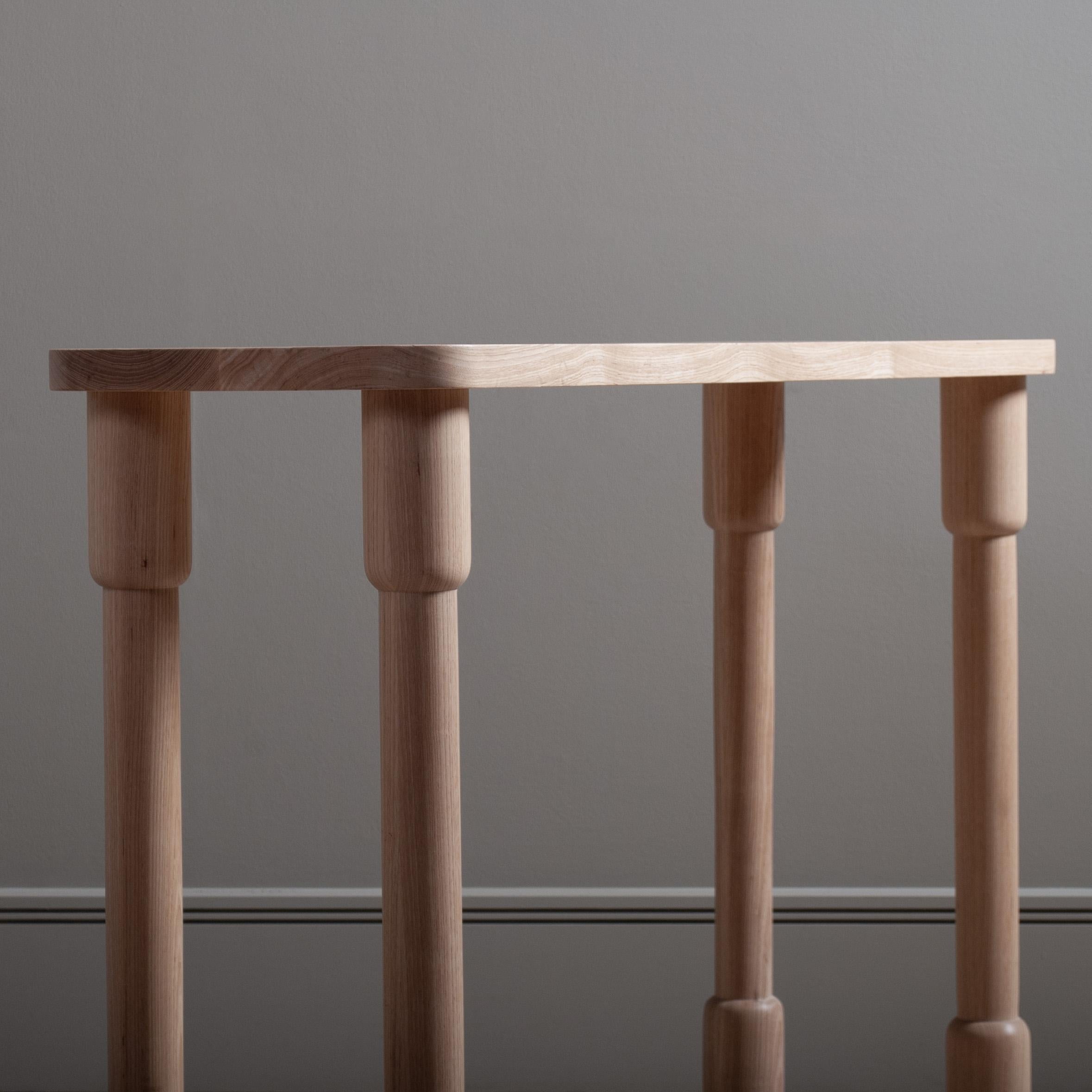 Architectural maunsell console table designed and handmade in England using traditional furniture making techniques. Completely handcrafted from prime English ash. Hand-turned legs jointed through and flush to the main surface.
A solid and striking