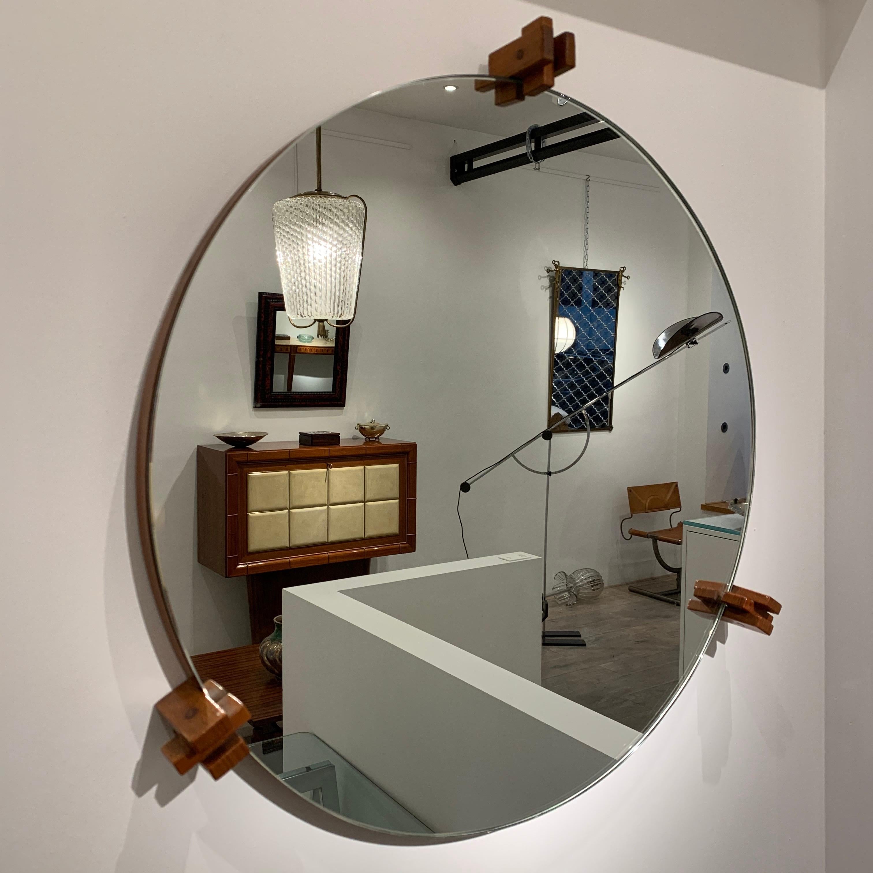 The design of the mirror is reduced to its basic function. The only decorative parts are the three wood structures that hold the mirror. This work is in the spirit of an architect like Gianfranco Frattini. It clearly shows the influence for simple