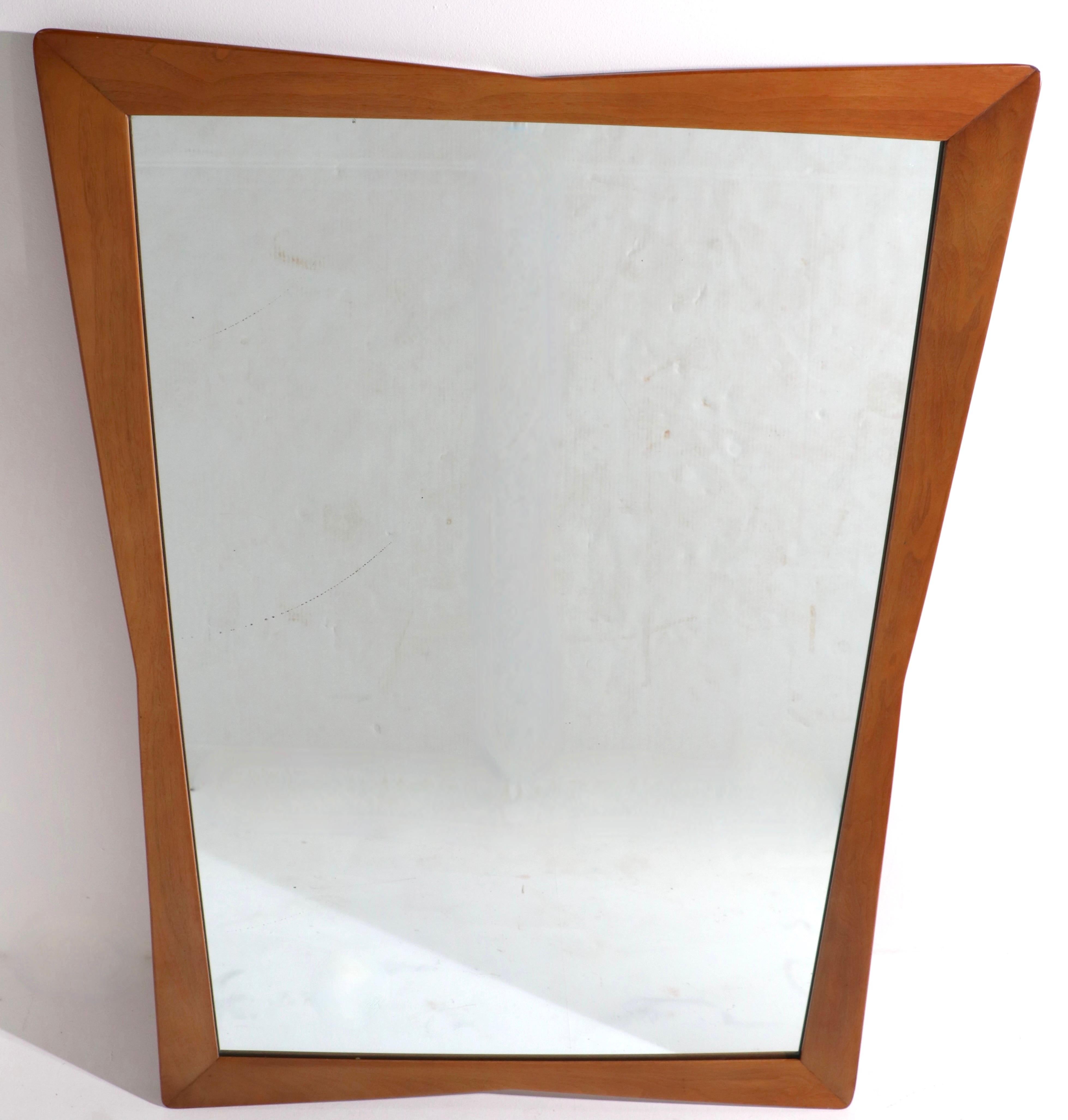 Stylish mid century wall mirror designed by Kent Coffey from The Sequence series. The solid walnut frame is of waisted form, becoming more narrow towards the middle, then widening at the outside edges. Nice large scale makes this impressive mirror