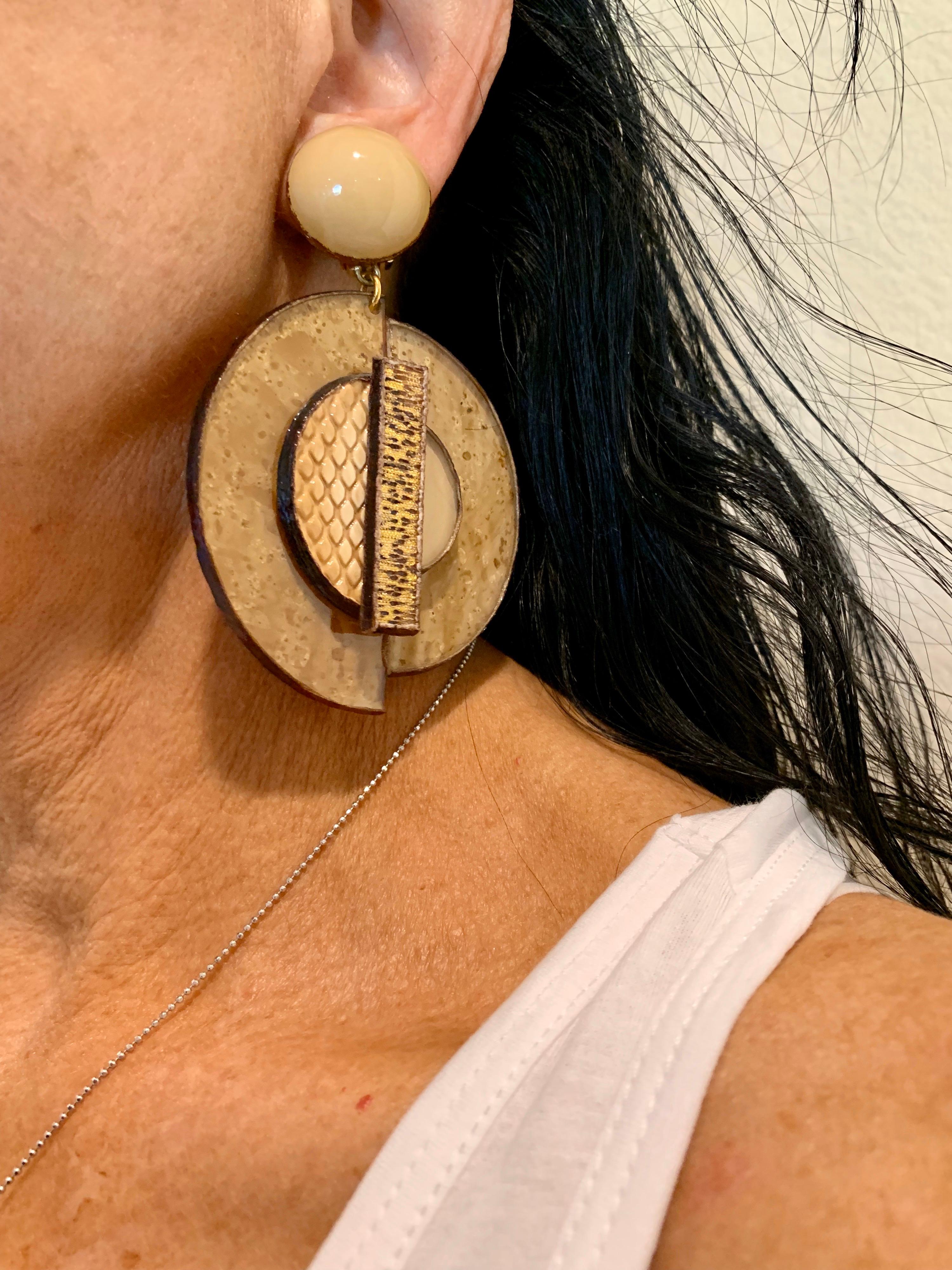 Light and easy to wear, these handmade artisanal circle clip-on earrings were made in Paris by Cilea. The earrings are comprised out of gold enameline (resin and enamel composite) and depict three-dimensional pop art circles. Throughout the earrings